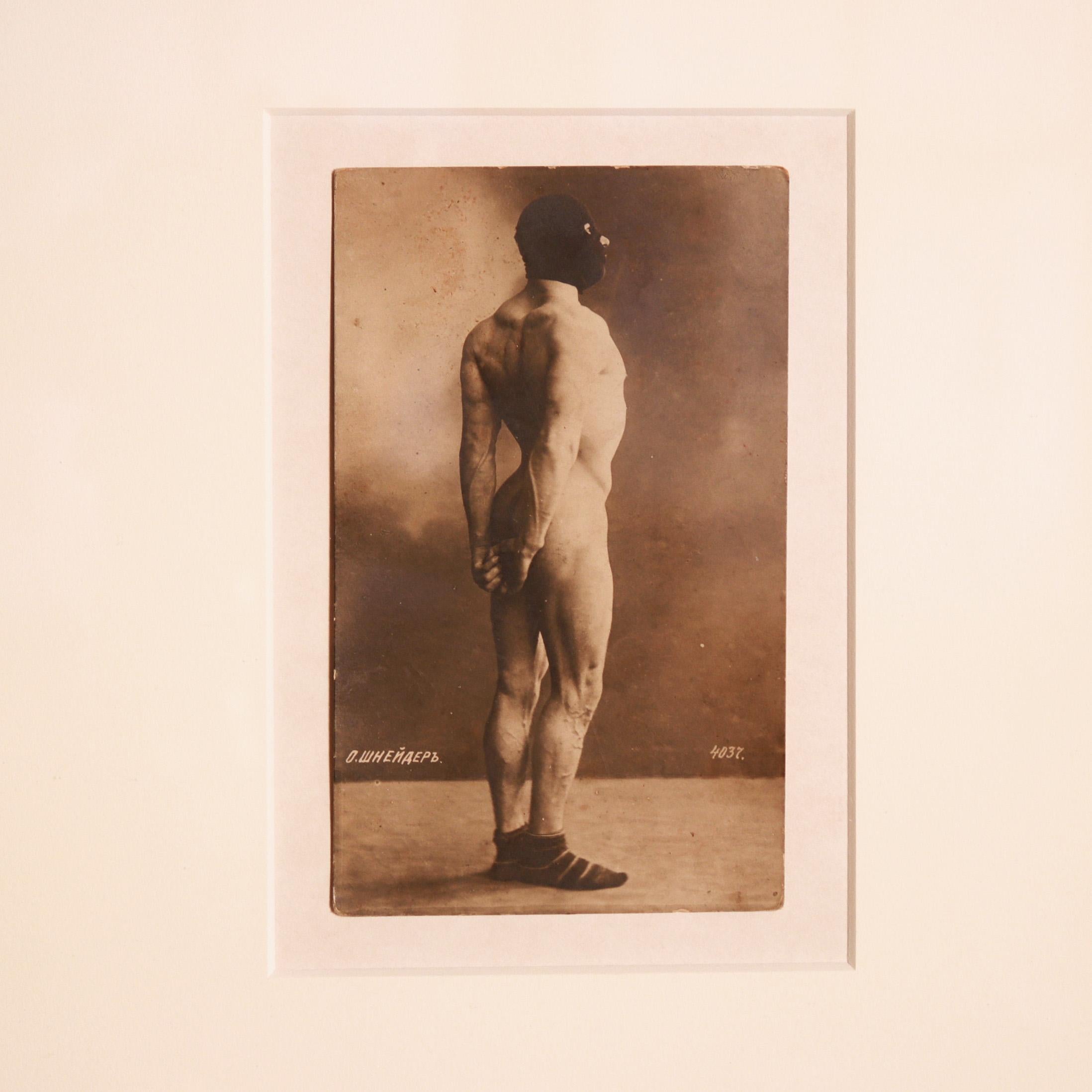 ‘Schneider’, a turn of the 20th century uncirculated sepia-toned homoerotic Russian bodybuilder photo-printed postcard.
In the late 19th and early 20th centuries, strongmen were circus performers who exhibited great feats of strength. Many of these