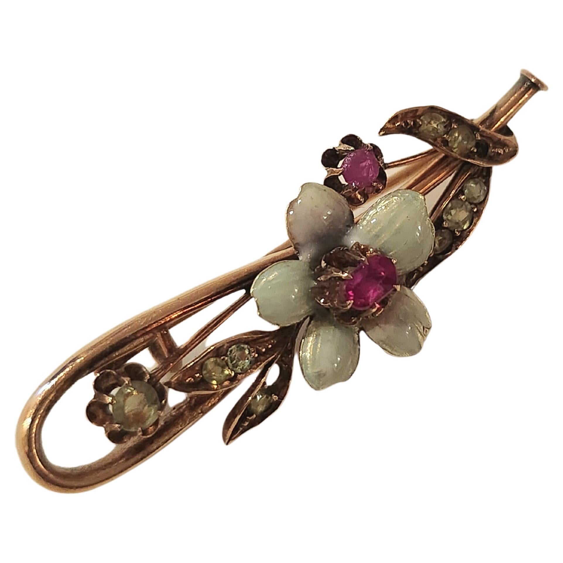 Antique imperial russian era brooch with demantoid and ruby decorted with an enamel flower brooch was made in moscow 1907.c during the imperial russian era hall marked 56 imperial russian gold standard and moscow assay mark total lenght 4.2cm 