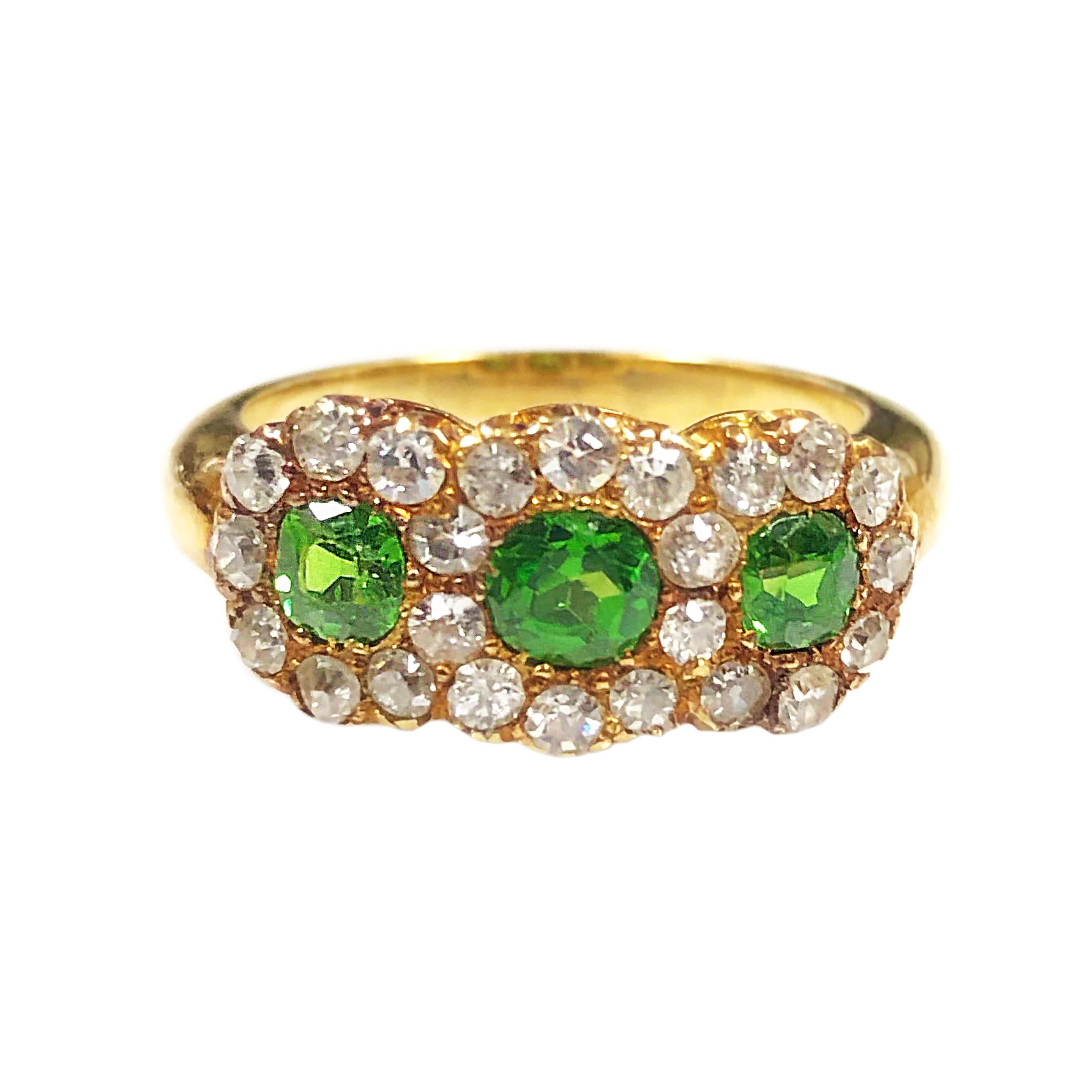 Circa 1900 14K Yellow Gold Ladies Ring, measuring 3/4 X 5/16 inch, set with 3 Cushion cut Fine Color Ural Demantoid Garnets. Surrounded by Old European cut Diamonds totaling 1 Carat. Finger size 6 1/2.  Excellent, near unworn condition. 