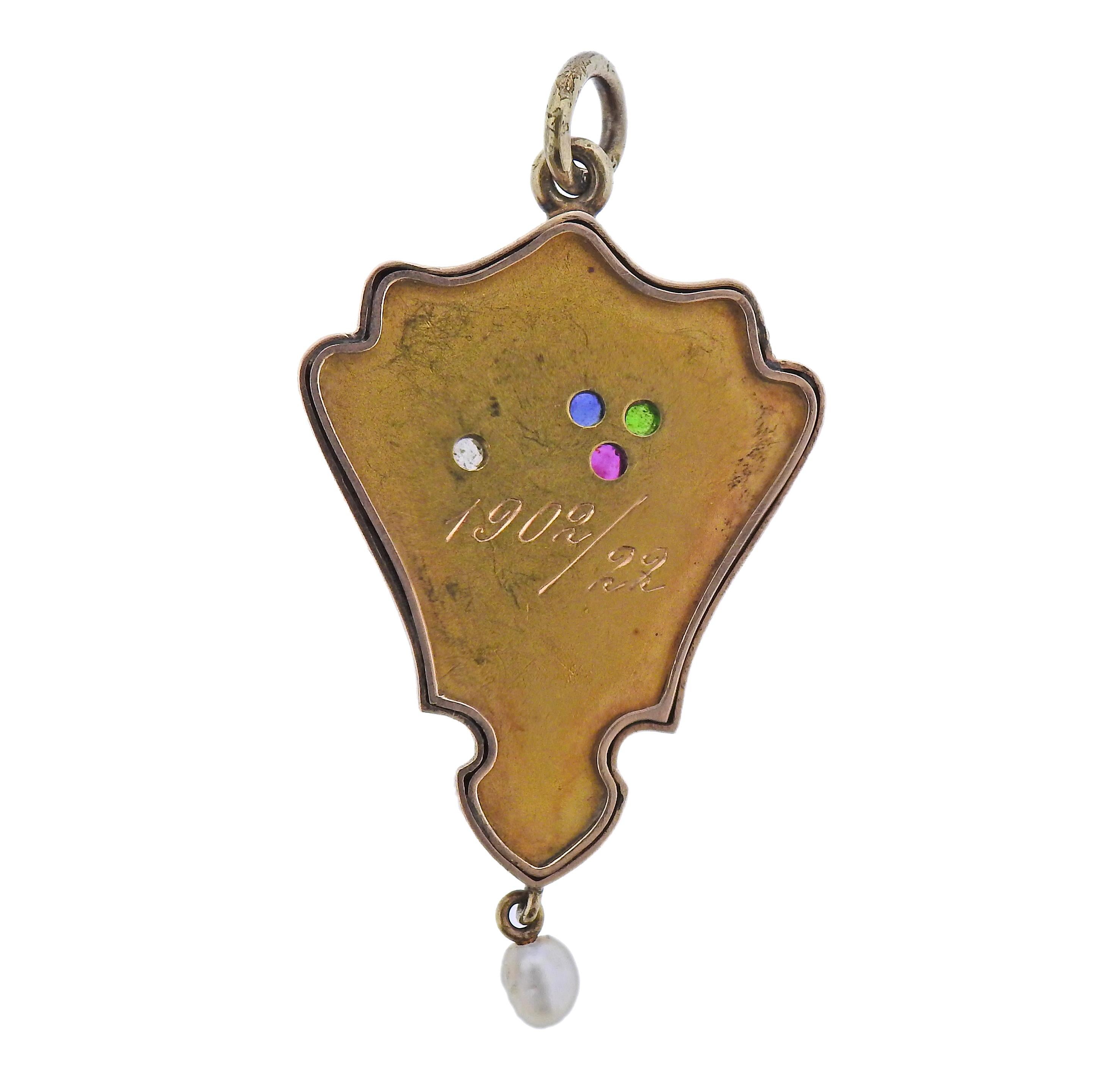 Colgante antiguo de oro de 14 quilates, fabricado en Rusia, hacia 1900. Engastada con un diamante, un rubí, un zafiro, una esmeralda, esmalte en la parte posterior y una perla en forma de gota. El colgante mide 53 mm x 28 mm. Marcado con marcas