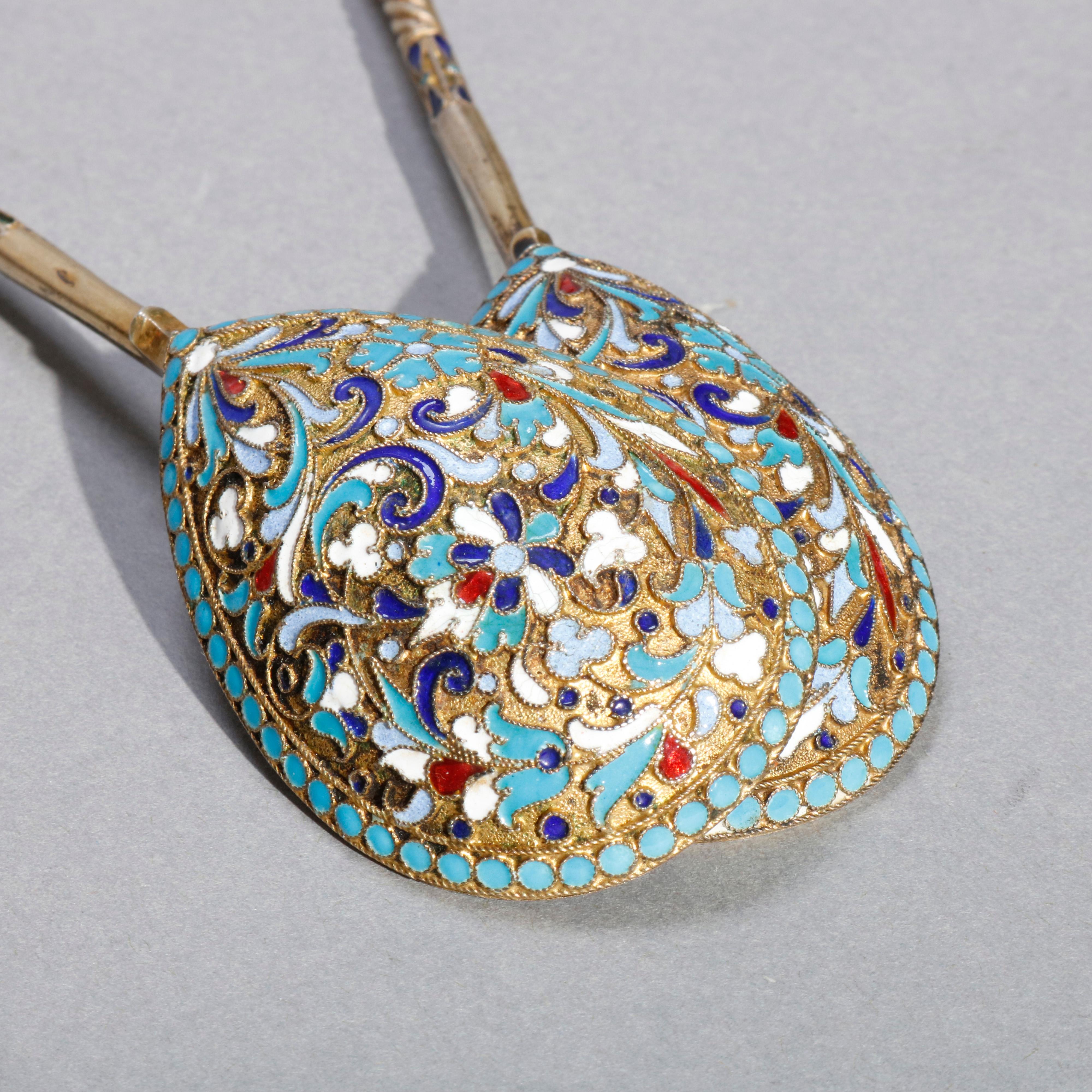 An antique pair of Russian long spoons offer 84 silver with teardrop bowls, scroll and foliate enamel decoration throughout, unmarked, circa 1900. 

Measures- 6.88