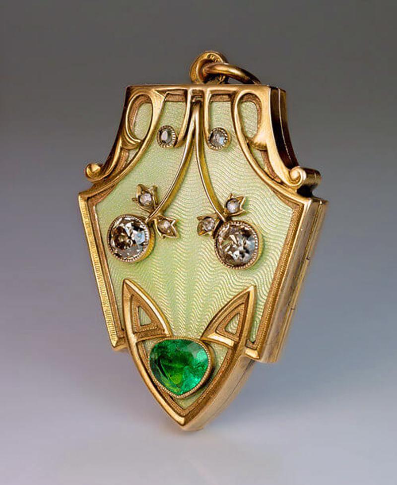 This superb Art Nouveau antique locket pendant was made in St. Petersburg between 1904 and 1908.

The front of the locket is covered with a very fine pale golden green guilloche enamel and applied with a pair of stylized diamond-set cherries within