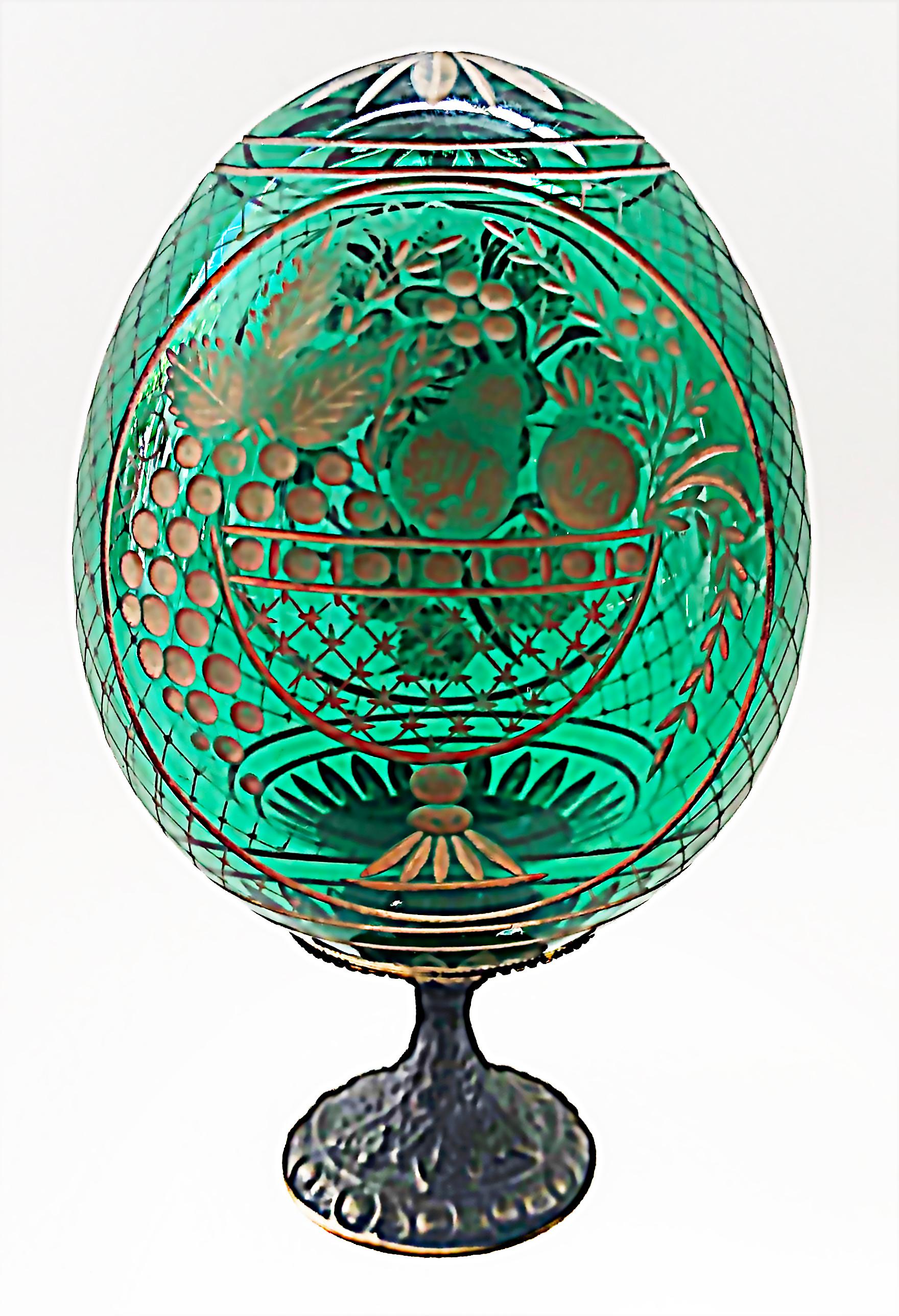 Antique Russian Floral Cut crystal egg on brass stand

Offered for sale is an antique green crystal egg decorated on the sides with cut and gilt floral and fruit bowl motifs. There are lattice cut patterns on the sides and a gilt starburst design