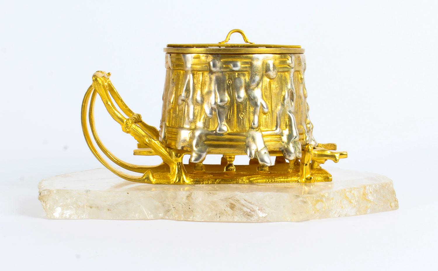This exceptional Russian ormolu and rock crystal encrier inkwell dates from circa 1840.

The omolu inkwell is modelled as an overflowing barrel on a sled. The pan cover lifts off using the central handle and it is pierced for pounce. Pounce is a