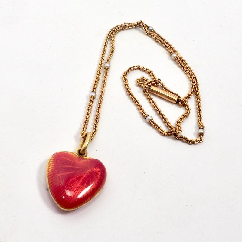 A beautiful Russian guilloche enamel  heart shaped locket set with a diamond. The heart shaped locket opens to reveal a glass panelled cartouche, Russian hallmarks. With associated gold and pearl station chain, 
Approx. 2 cm x 1.5 cm 0.35 cm deep.