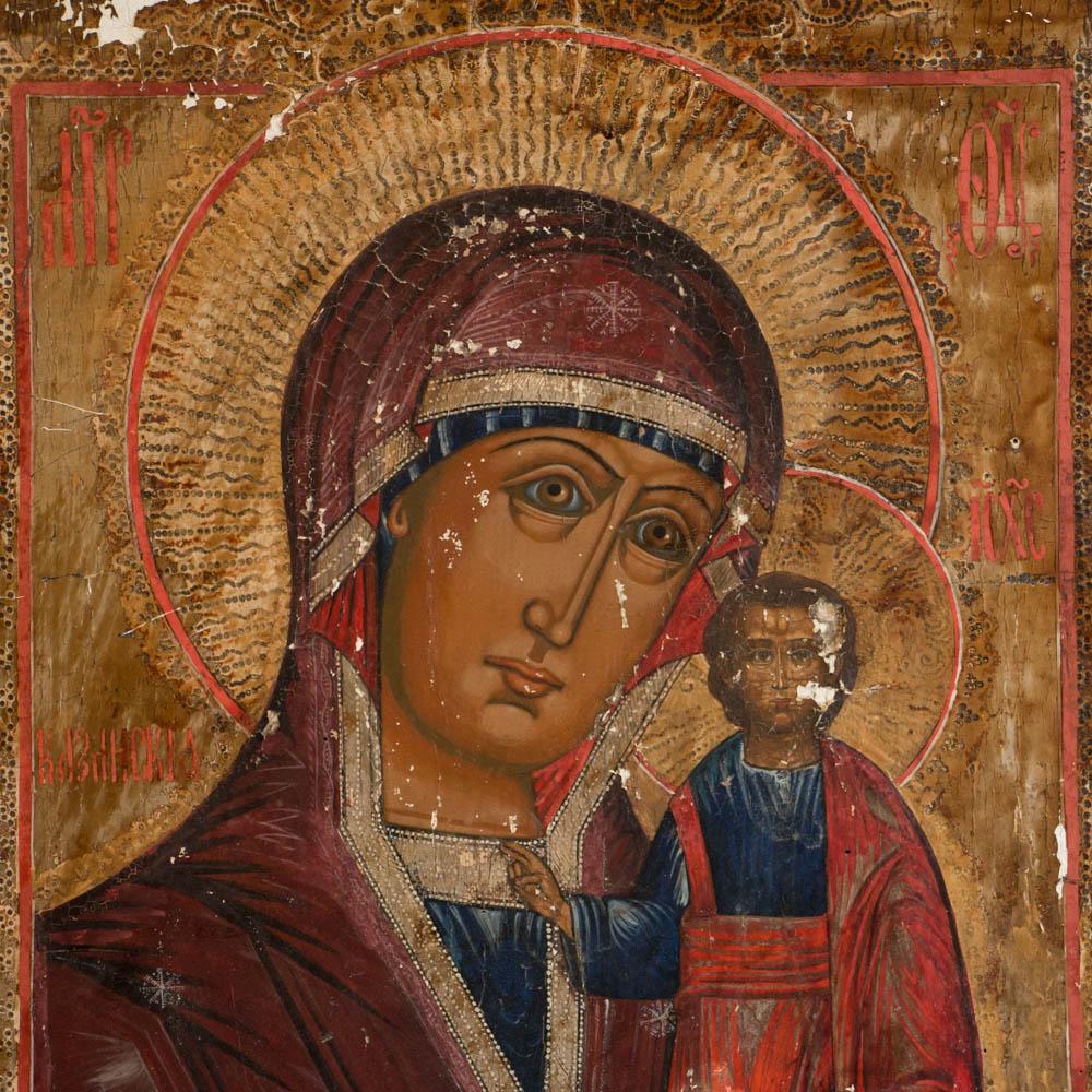 A mid-19th century Russian Icon of the virgin Mary holding the Christ Child flanked on both sides by saints in the margins. The painting is on a gessoed canvas mounted on a thick wood board. There is minor paint loss throughout the painting. Please