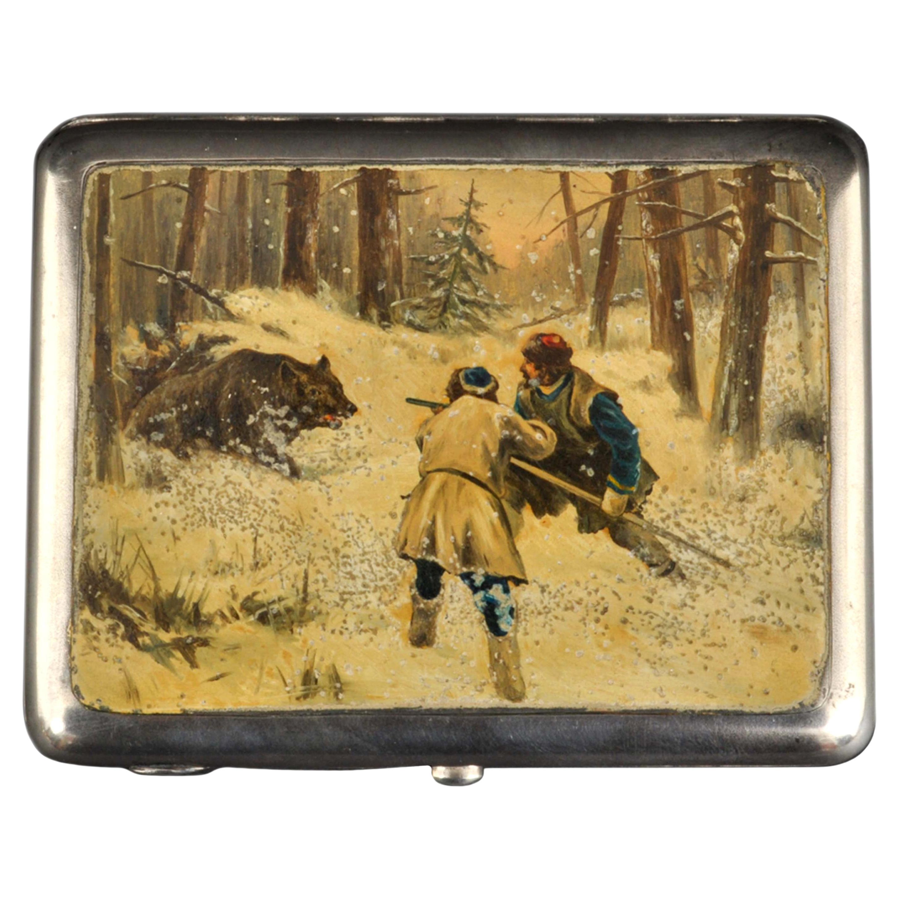 Antique Russian Imperial silver & enamel cigarette case, 1898-1914.
A rare & unusual antique Russian silver case with an enameled pictorial hunting scene to the front, depicting two Russian men in a snowy forested landscape hunting a bear. The