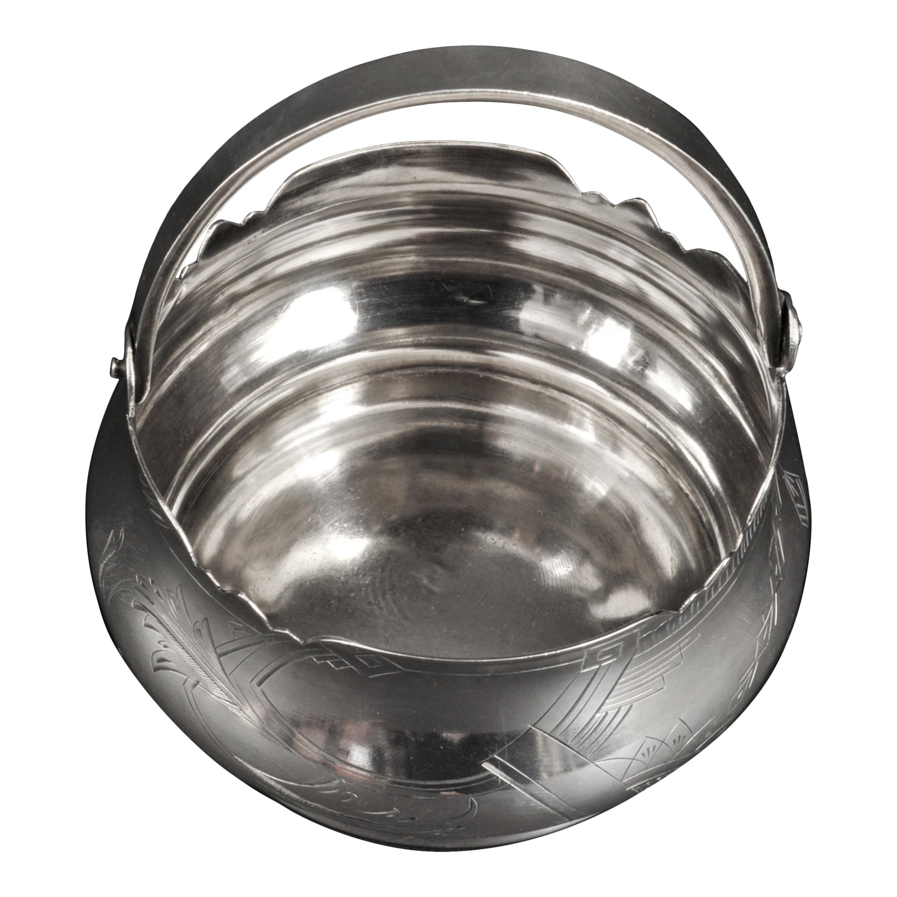 Buen cesto o cuenco imperial ruso de plata grabada con asa oscilante, Moscú, hacia 1910.
Esta cesta de plata prerrevolucionaria, probablemente diseñada para bombones o dulces, tiene un asa oscilante con un borde perfilado y un cuerpo en forma de