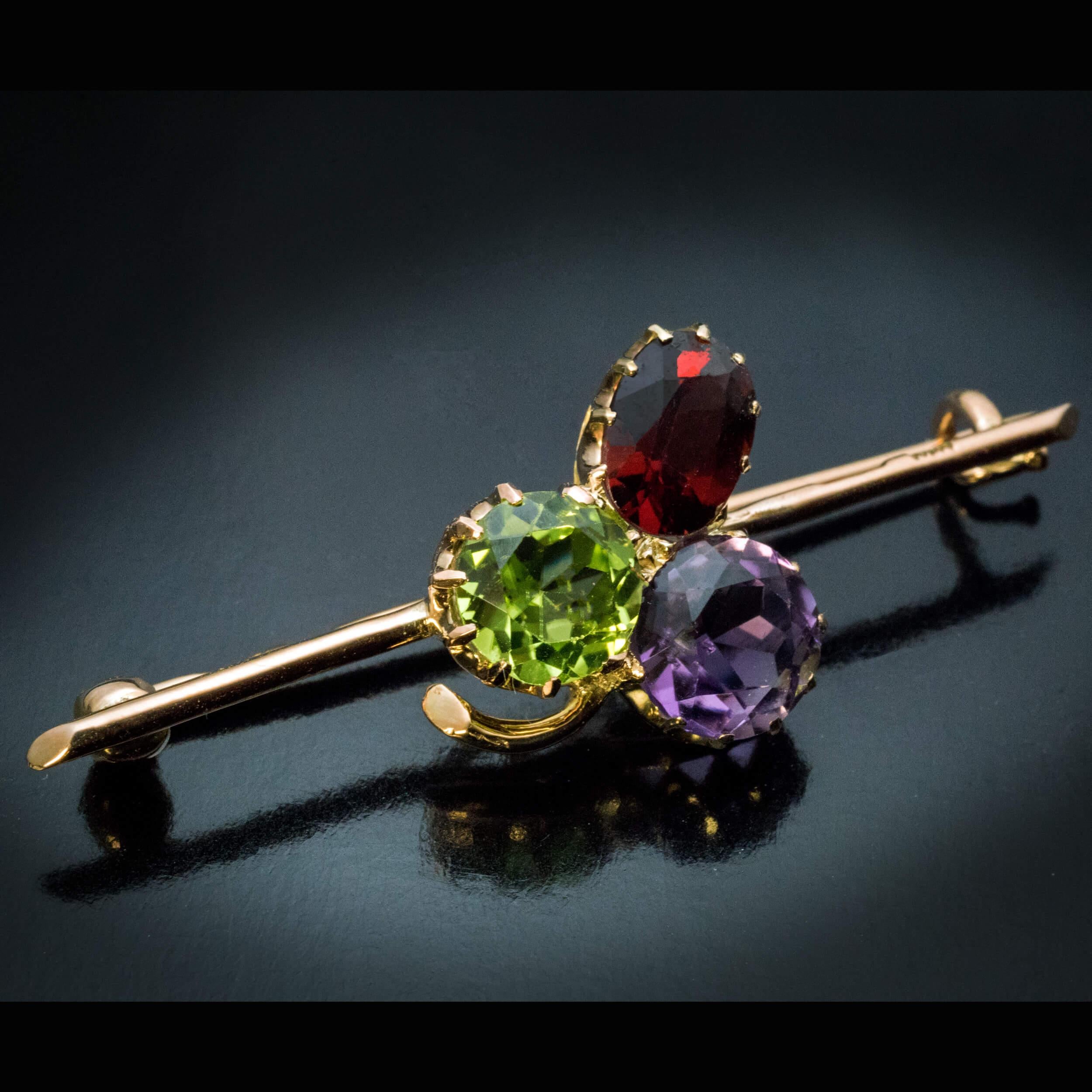 Made in Moscow between 1899 and 1908.
The 14K gold trefoil brooch is set with a dark red garnet, a bright apple green chrysolite and a lavender purple amethyst.
The brooch is marked with 56 zolotnik Imperial gold standard with assayer’s initials