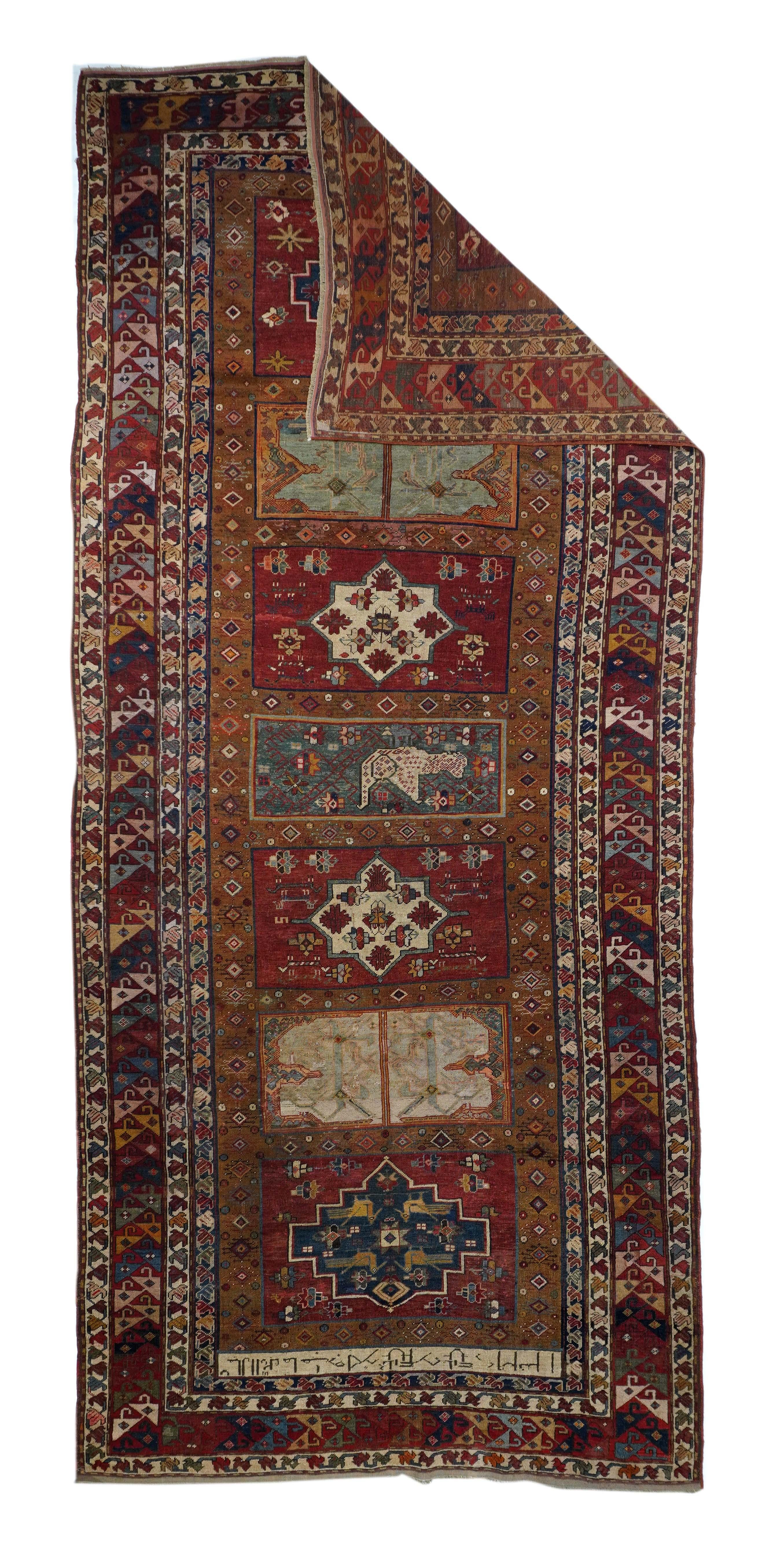 Antique Kazak Rug 5'10'' x 13'8''. The tomato red field displays seven separate panels in dark red, green, navy, straw and beige. Birds in central green rectangle flanked by two panels with ivory octogramme stars Dark red border with variously