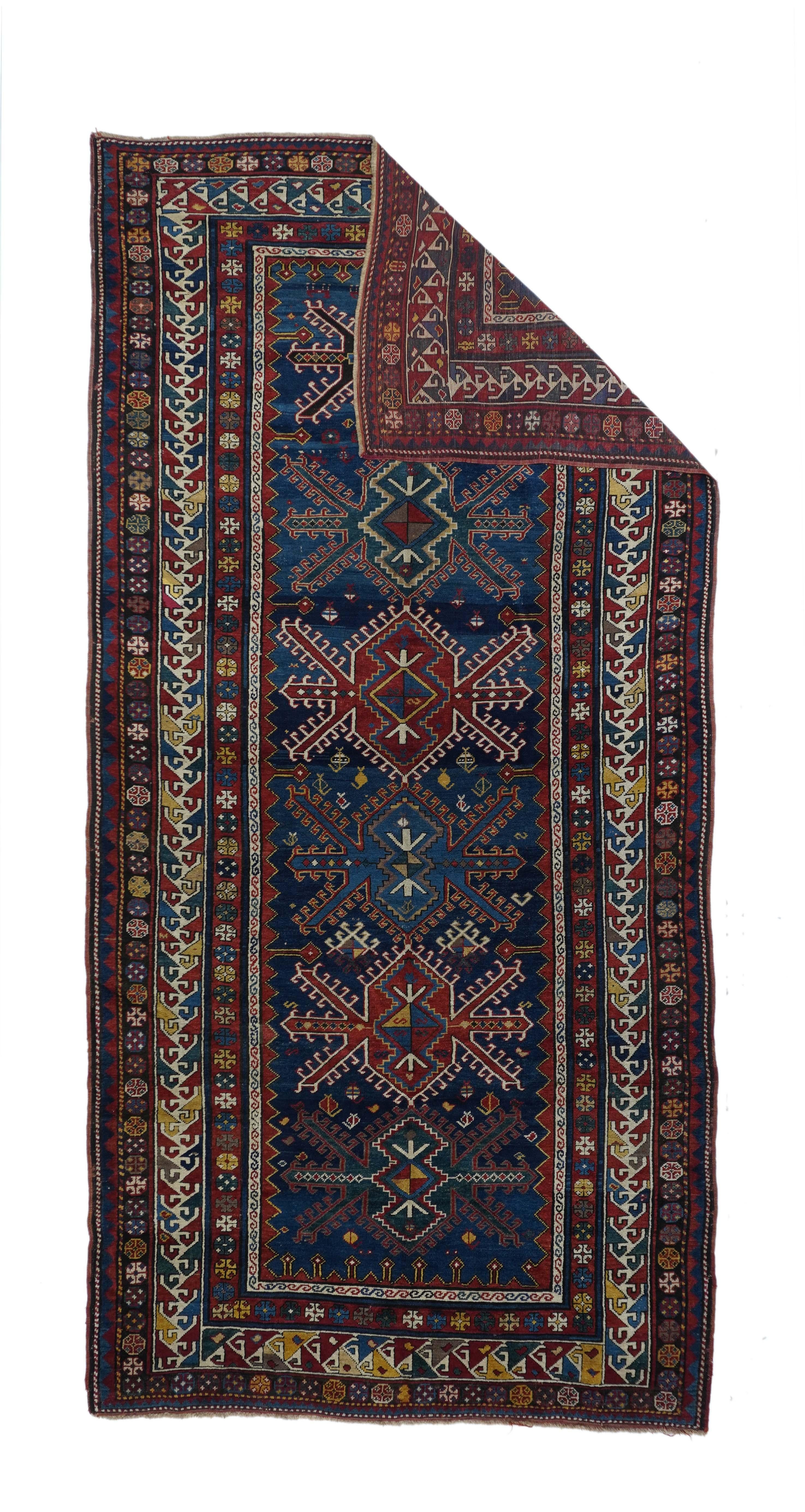 Tapis Kazak antique 5'7'' x 11'11''. Ce grand Kazak (tapis long) sur laine, au tissage modéré, présente un champ bleu foncé bien abrasé, avec six médaillons de style turkmène en rouge et bleu moyen, et des bordures uniformes avec des crochets.