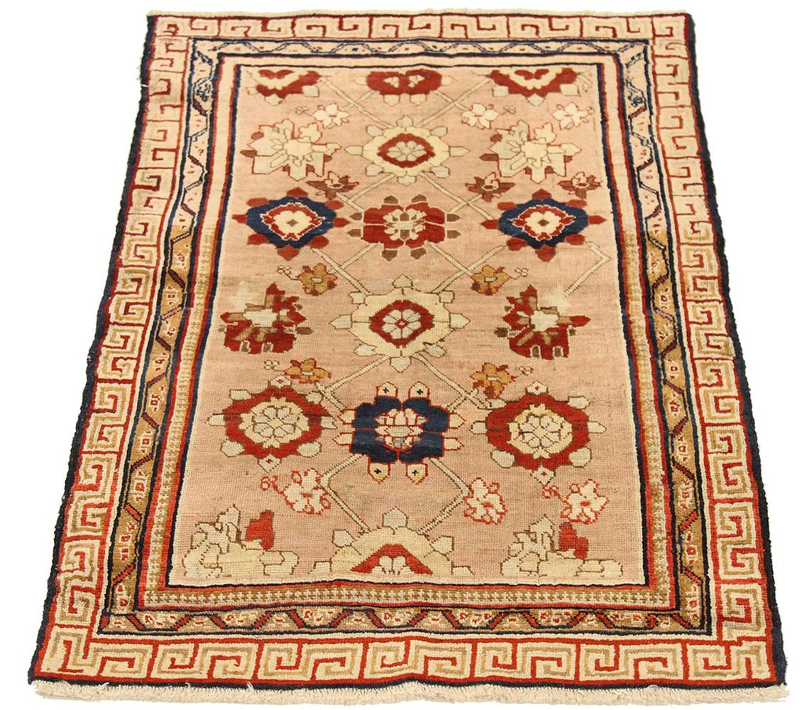 Antique Russian rug handwoven from the finest sheep’s wool and colored with all-natural vegetable dyes that are safe for humans and pets. It’s a traditional Kazak design featuring floral medallion details in navy and red over a beige field. It’s a