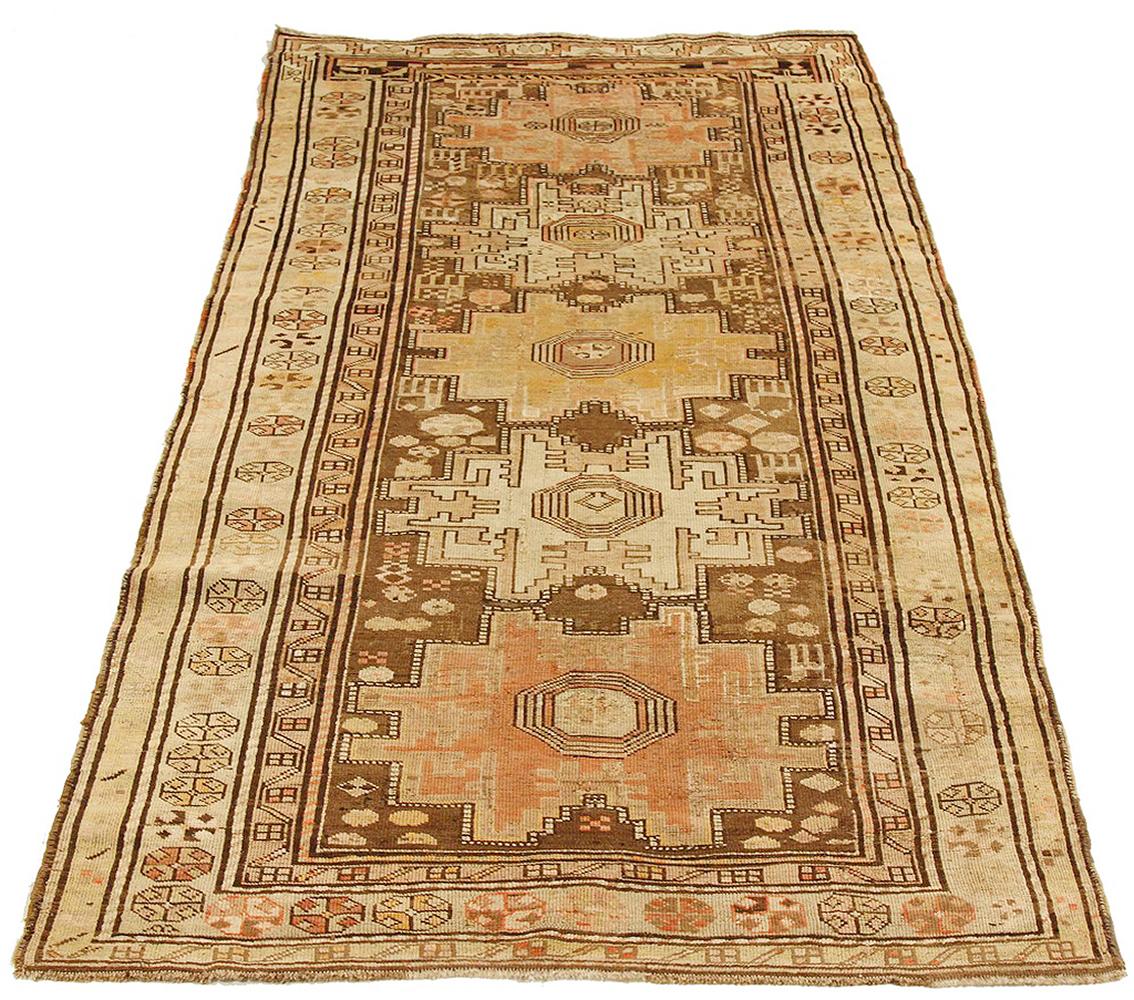 Antique Russian rug handwoven from the finest sheep’s wool and colored with all-natural vegetable dyes that are safe for humans and pets. It’s a traditional Kazak design featuring rustic-colored medallion details on a brown center field. It’s a