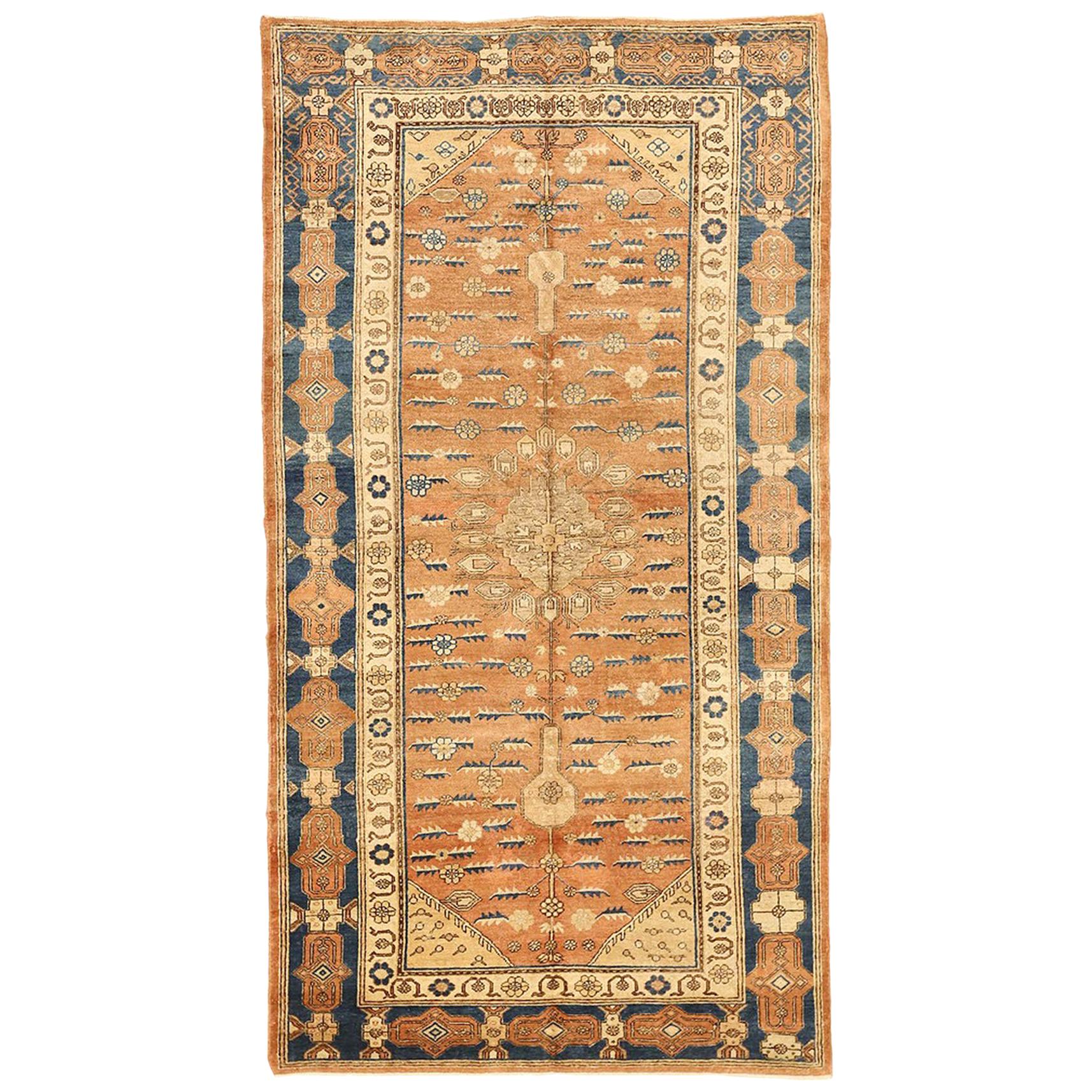 Alfombra Khotan rusa antigua con motivos florales azules y beige sobre fondo marrón
