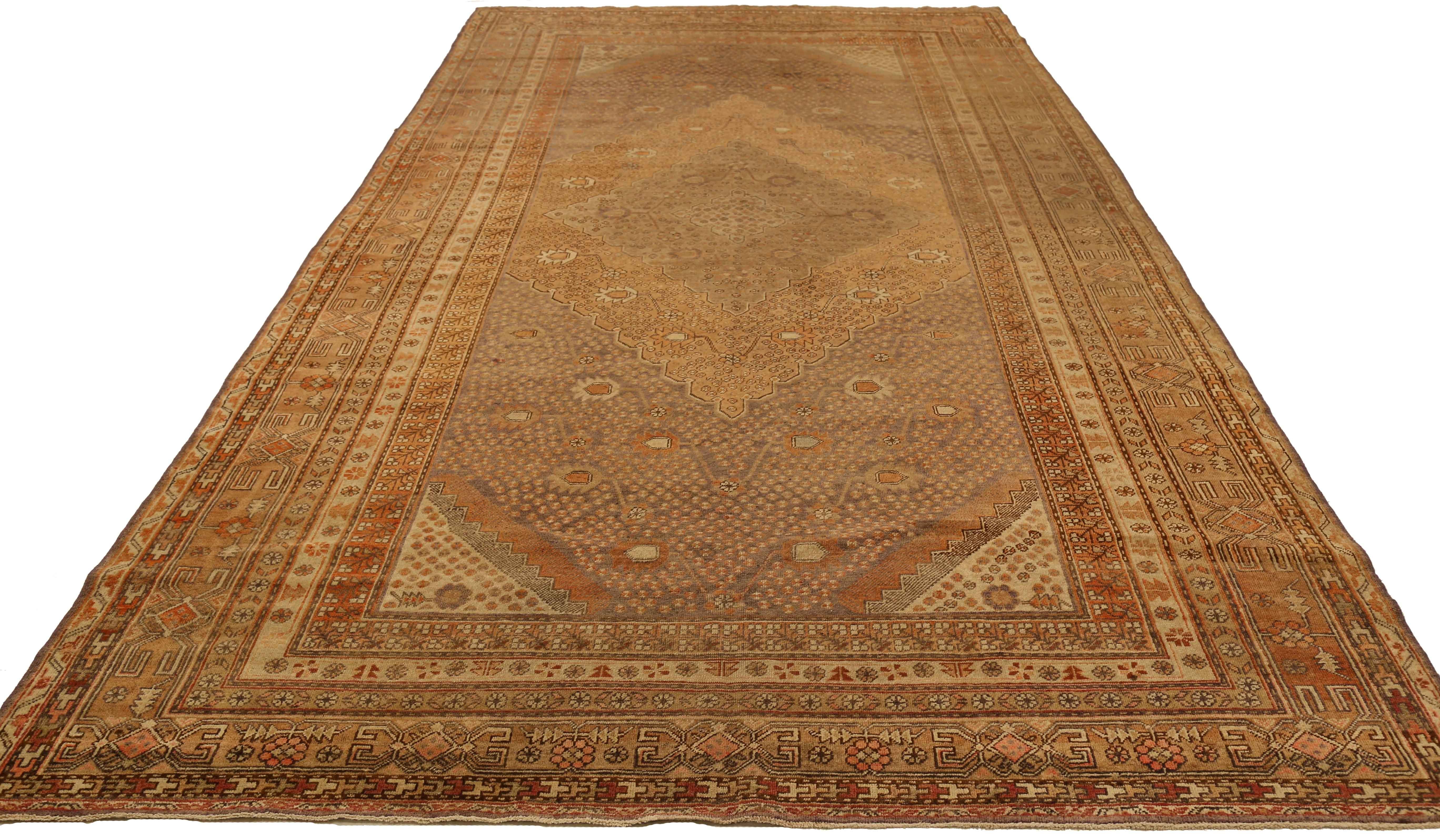 Antique Russian rug handwoven from the finest sheep’s wool and colored with all-natural vegetable dyes that are safe for humans and pets. Its woven using Khotan design featuring floral details in ivory and brown arranged in a diamond shape. It’s a