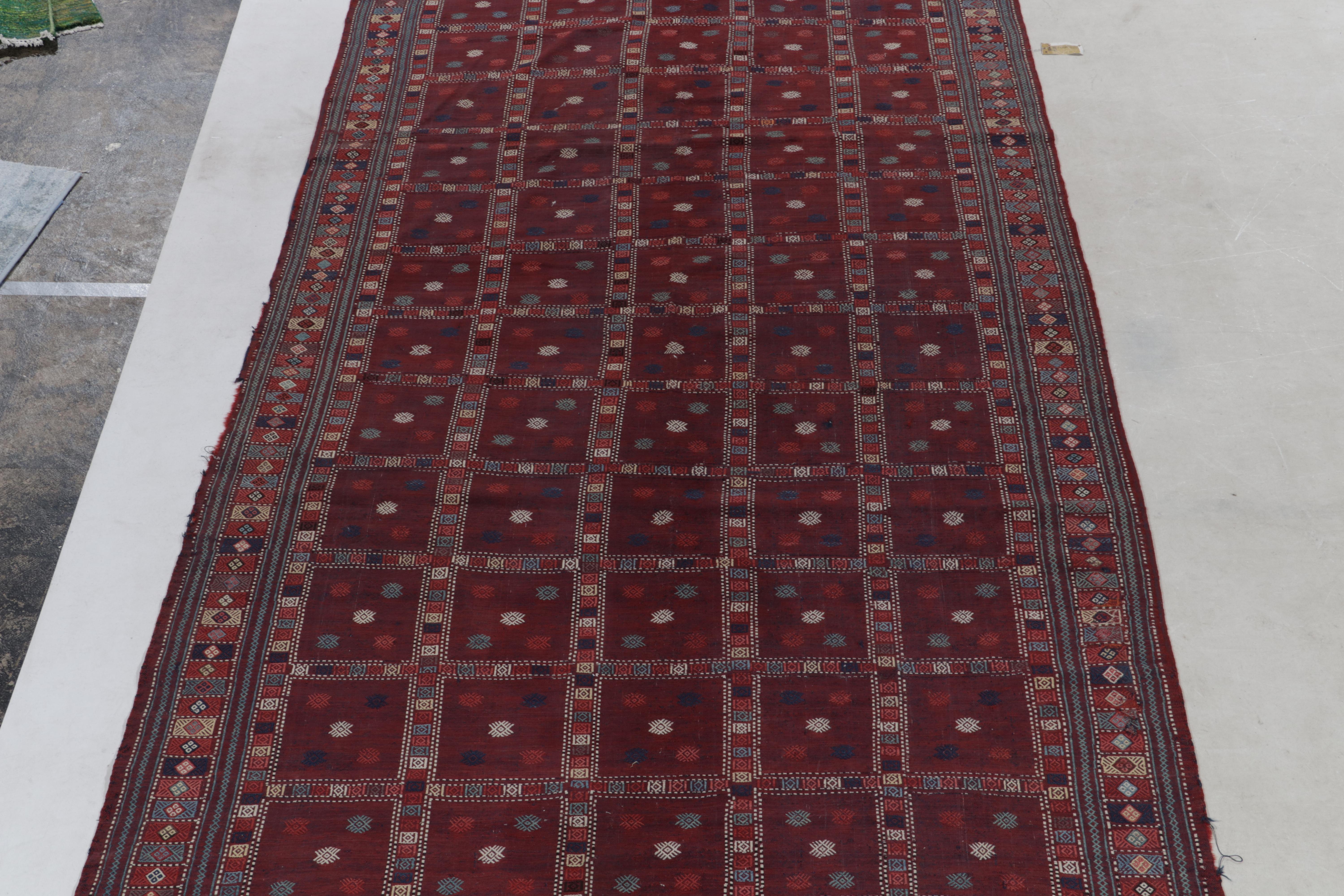 Ein handgewebter 6 x 12 großer antiker russischer Kelim aus Wolle, der die kaukasische Stammesästhetik verkörpert und jetzt in das Flachgewebe-Sortiment von Rug & Kilim aufgenommen wurde. Die tiefen wein- und bordeauxroten Töne ergänzen die