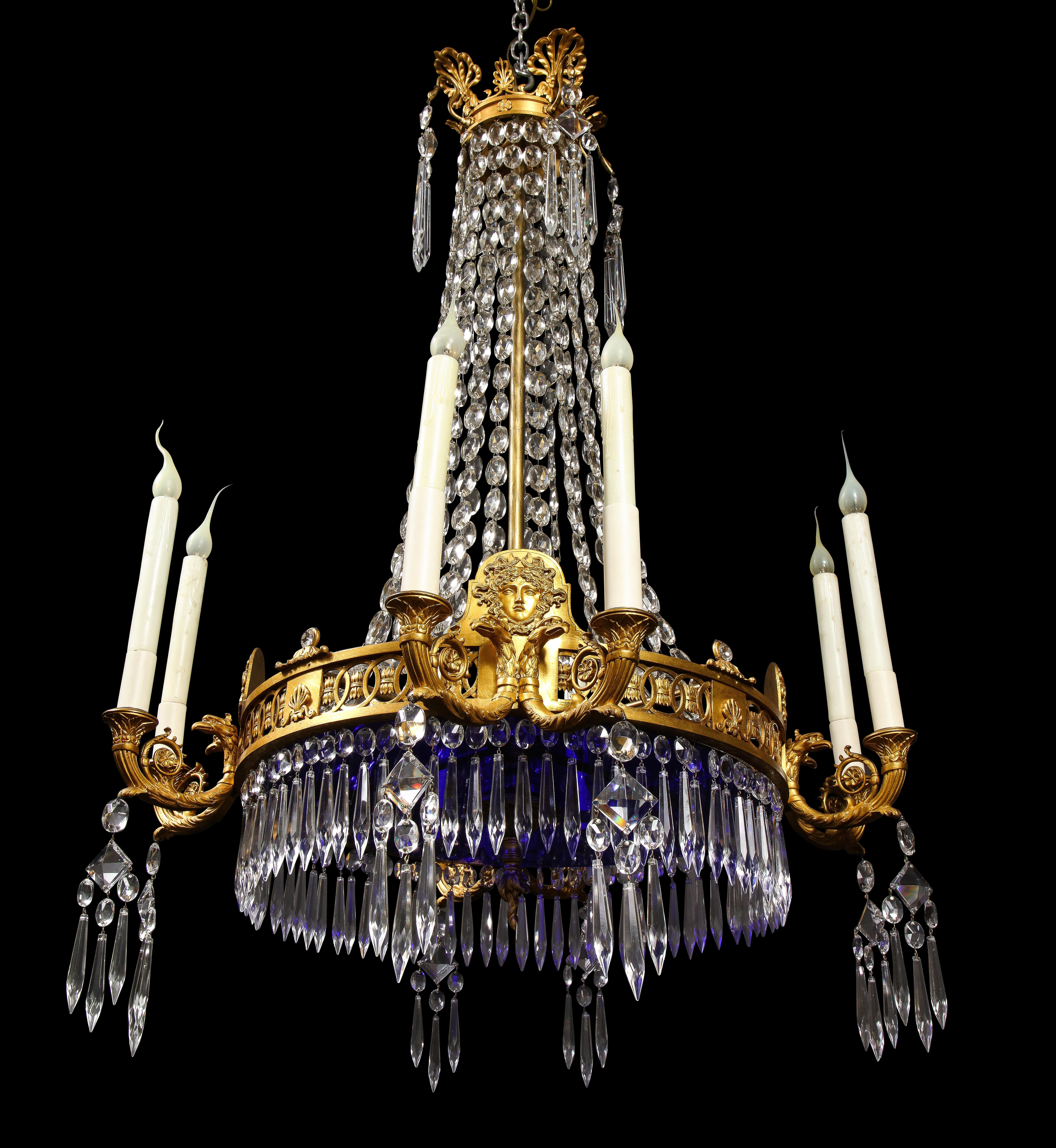 A Fine Large Antique Russian neoclassical gilt bronze, cut crystal and cobalt glass multi light chandelier of great detail embellished with neoclassical figural masks, gilt bronze swans and gilt bronze eagles This fine chandelier is further adorned