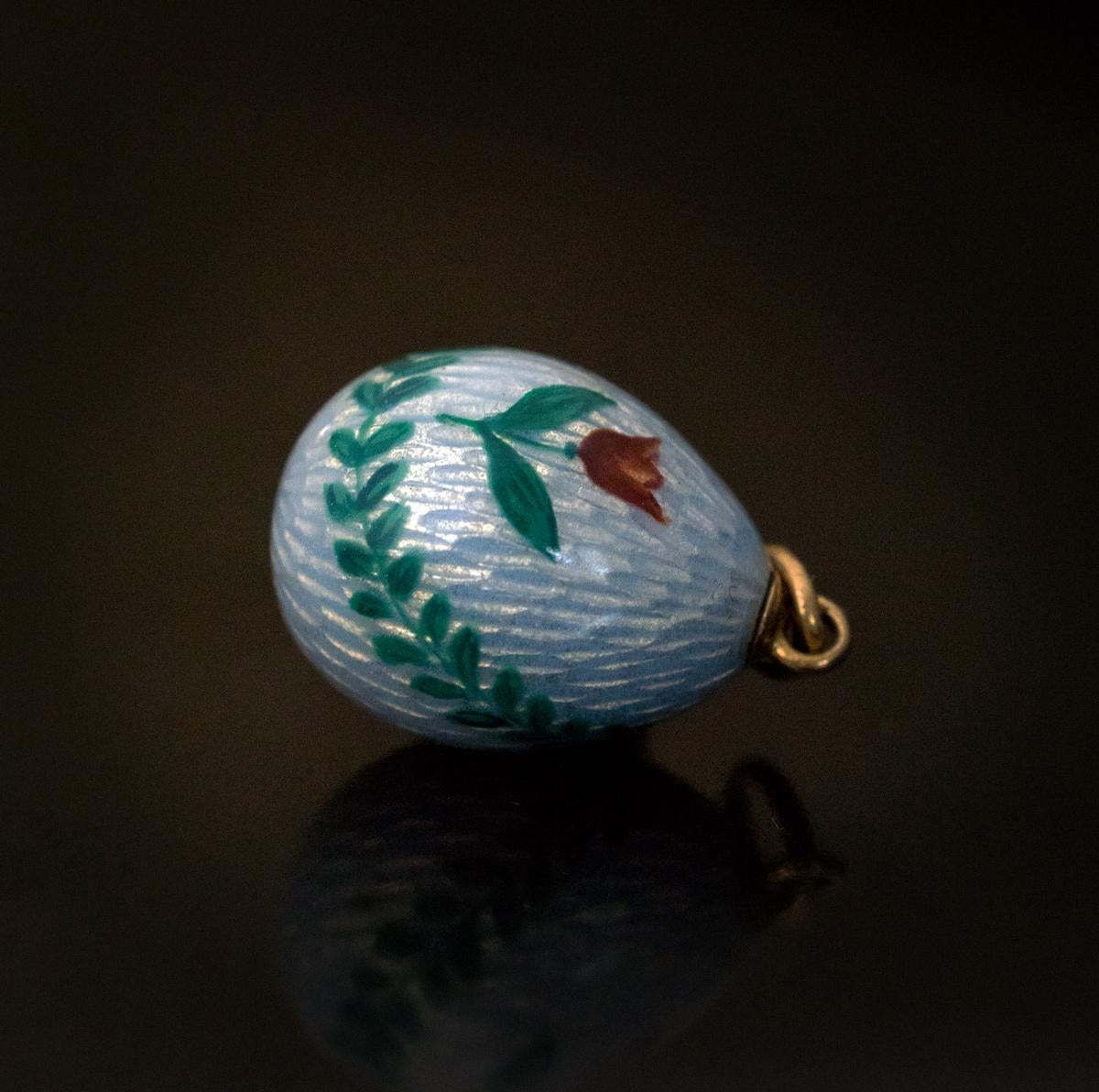Made between 1908 and 1917.

A charming antique Russian pale blue guilloche enamel egg pendant is painted with two red tulips and a green leaf garland. The egg is marked on suspension ring with 56 zolotnik old Russian gold standard and maker’s