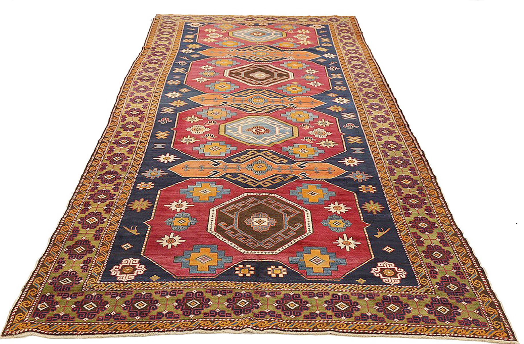 Antique Russian Shirvan rug handwoven from the finest sheep’s wool and colored with all-natural vegetable dyes that are safe for humans and pets. It’s a traditional Shirvan design featuring a mix of geometric and floral medallions in orange, red,