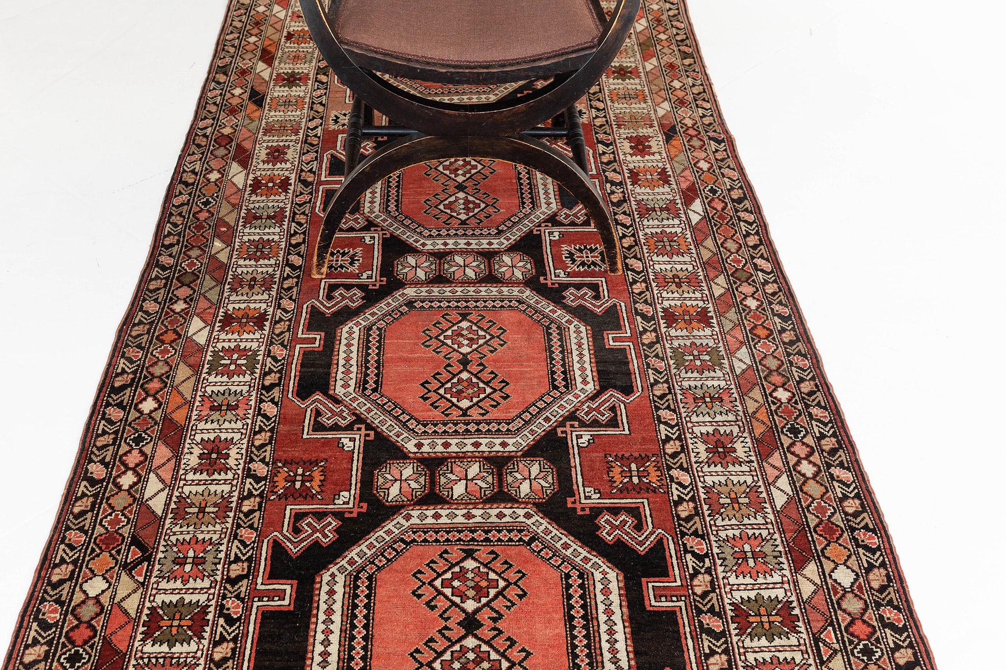 Our blushing antique Russian runner rug is a certified authentic piece. Inspired by tribal patterns, this hallway rug is a deal for flooring or wall applications. It is adorned with motifs and Russian tribal symbols and surrounded by geometrical