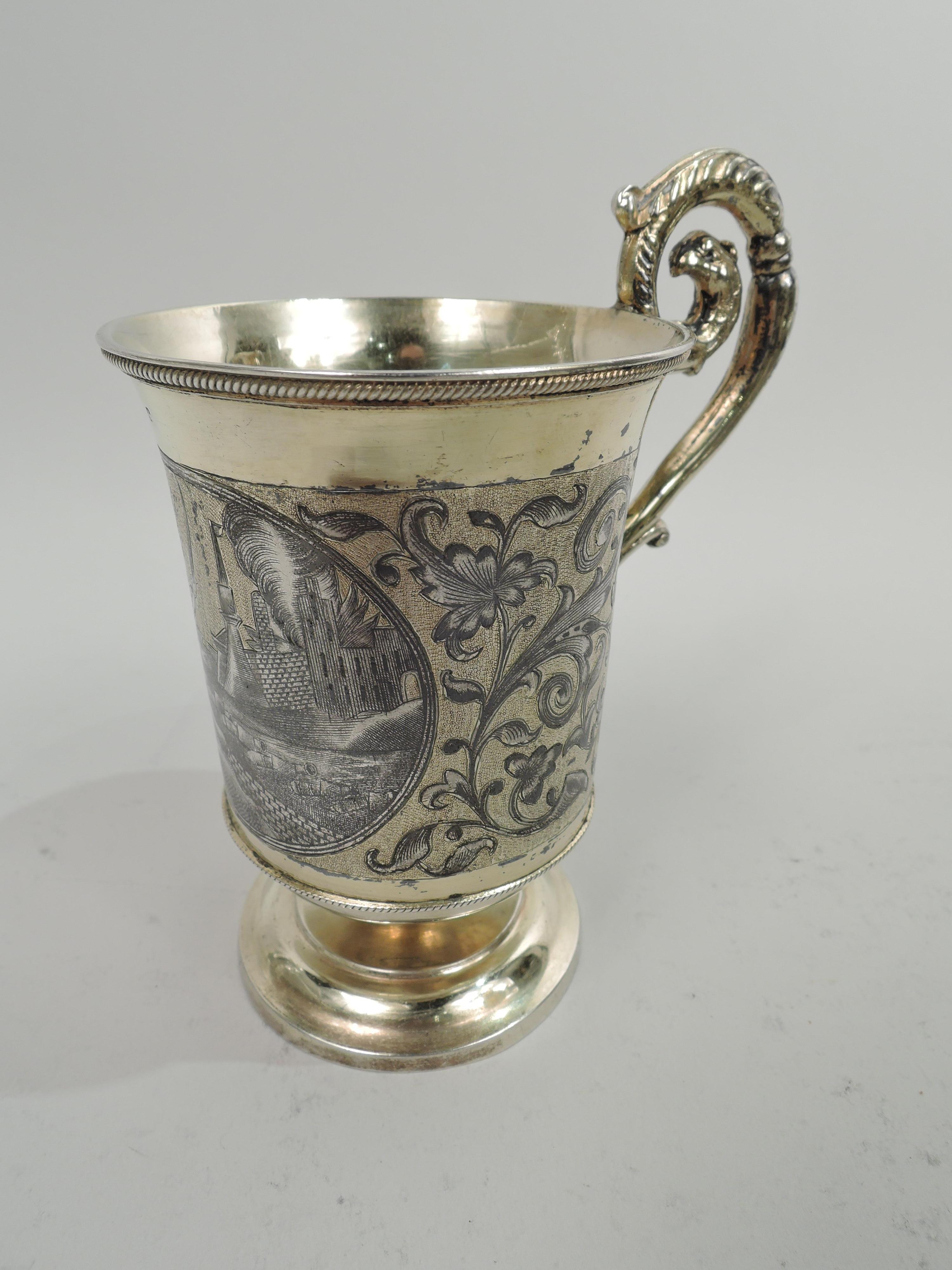 Russian gilt 875 silver christening mug, ca 1880. Bowl has flared rim, curved inset bottom, and gadrooned borders. Niello ornament with leafing and flowering scrollwork; in round frame, a scene from the Napoleonic Wars with a soldier raising a sword