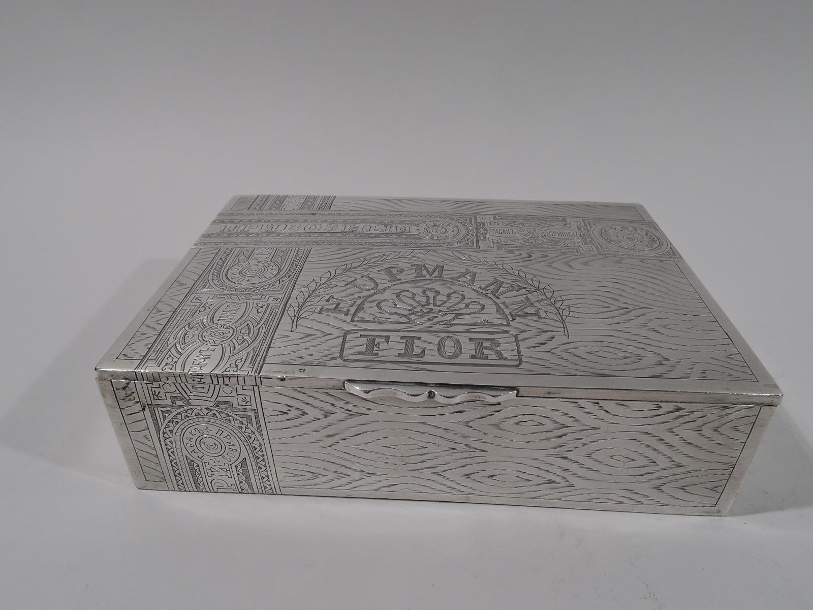 Russian 875 silver novelty cigar box, circa 1910. Rectangular; cover flat and hinged with scrolled tab. Trompe l’oeil wood panels with realistic grain and tax stamps. Box interior gilt-washed. On cover interior is engraved Russian script