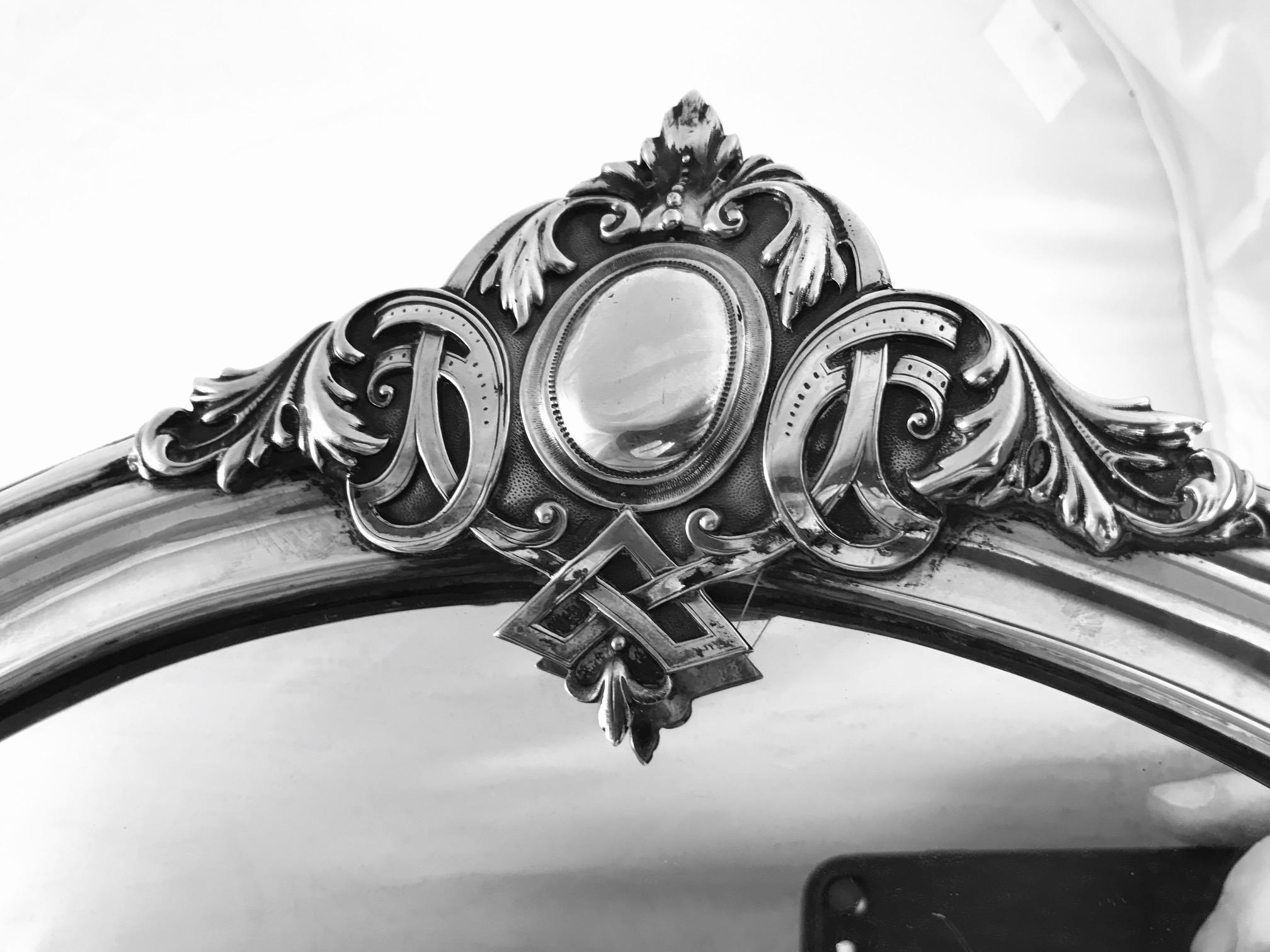 This is a Russian silver mirror in the Rococo Revival style by Moscow silversmith Dorofey Semyonovich Tikhomirov, Moscow.

The silver frame is attached to a wooden back and there is a folding metal stand which fits into the wooden