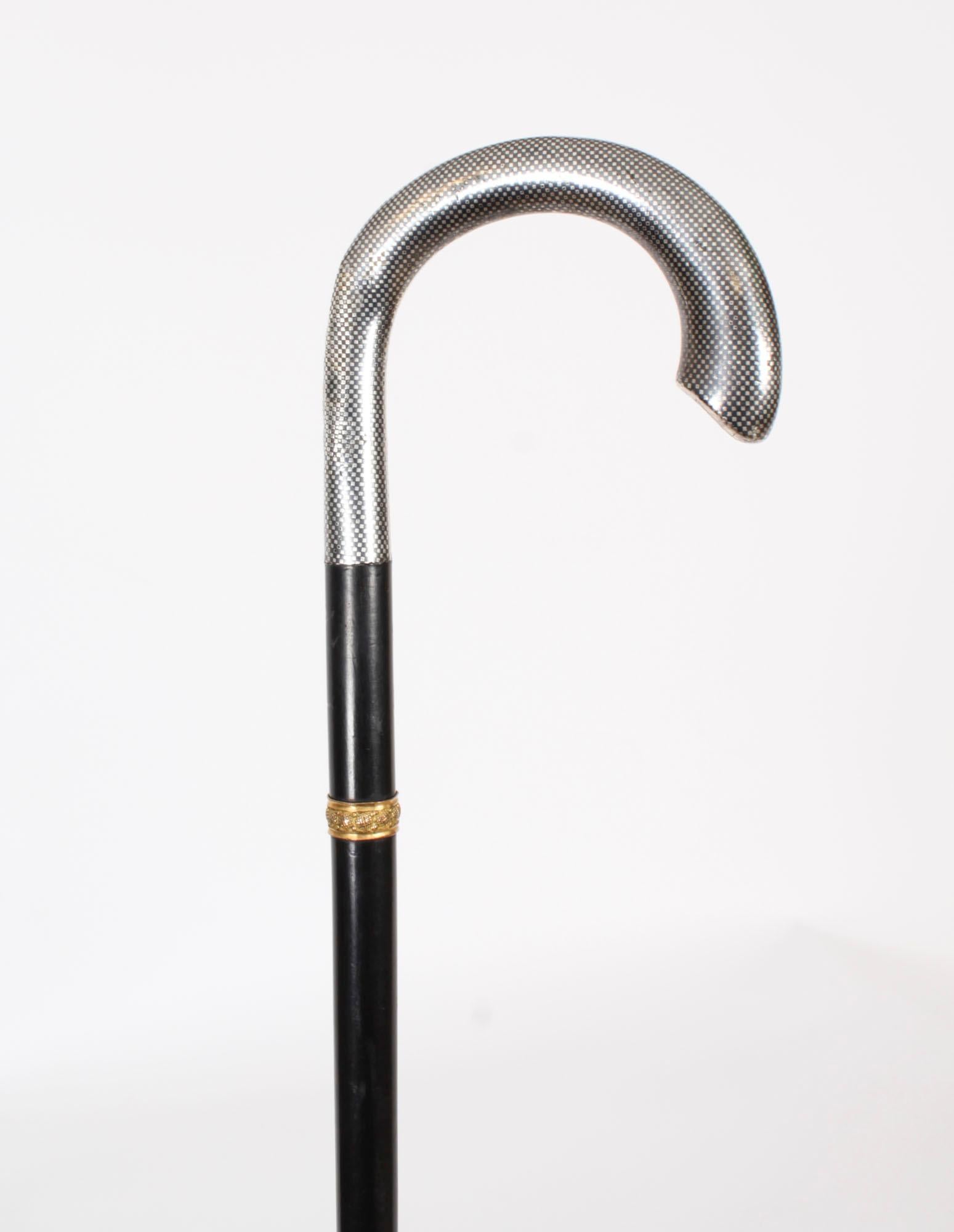 A decorative antique Russian silver niello handled walking cane, Circa 1880 in date.

It has a very decorative silver hook shaped handle with contours made with great attention to detail,  above a sturdy hardwood ebonised tapering shaft with a gold