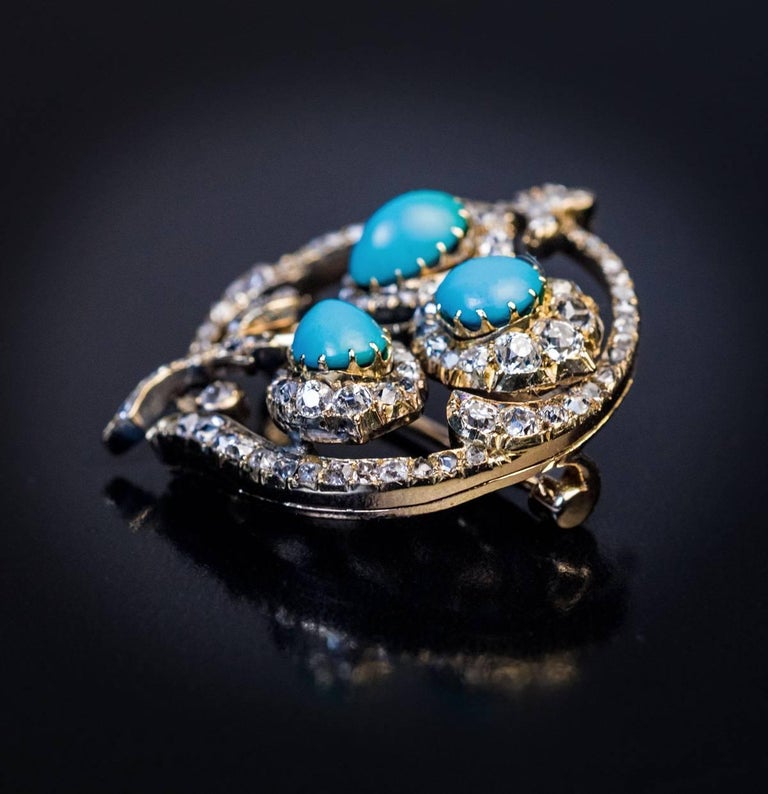 St. Petersburg, circa 1890

An antique Russian 14K gold brooch is designed as a stylized flower encircled by a floral-motif diamond frame. The flowerheads are set with one round and two pear shape Persian turquoise, each within a surround of cushion