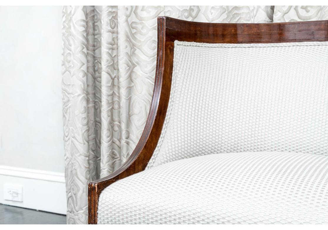 Neoclassical style Russian upholstered armchair with spring coil construction, tub back form, covered in textured fabric with double welt construction. The chair resting upon tapering block front legs and splayed back legs.

Dimensions: 25 1/4