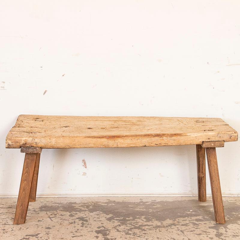 The thick slab top draws one to this rustic coffee table due to the heavy distress seen in every scratch, crack and gouge that came from years of constant use( likely in a butcher's shop). There is a slight bow to the top but one can still set