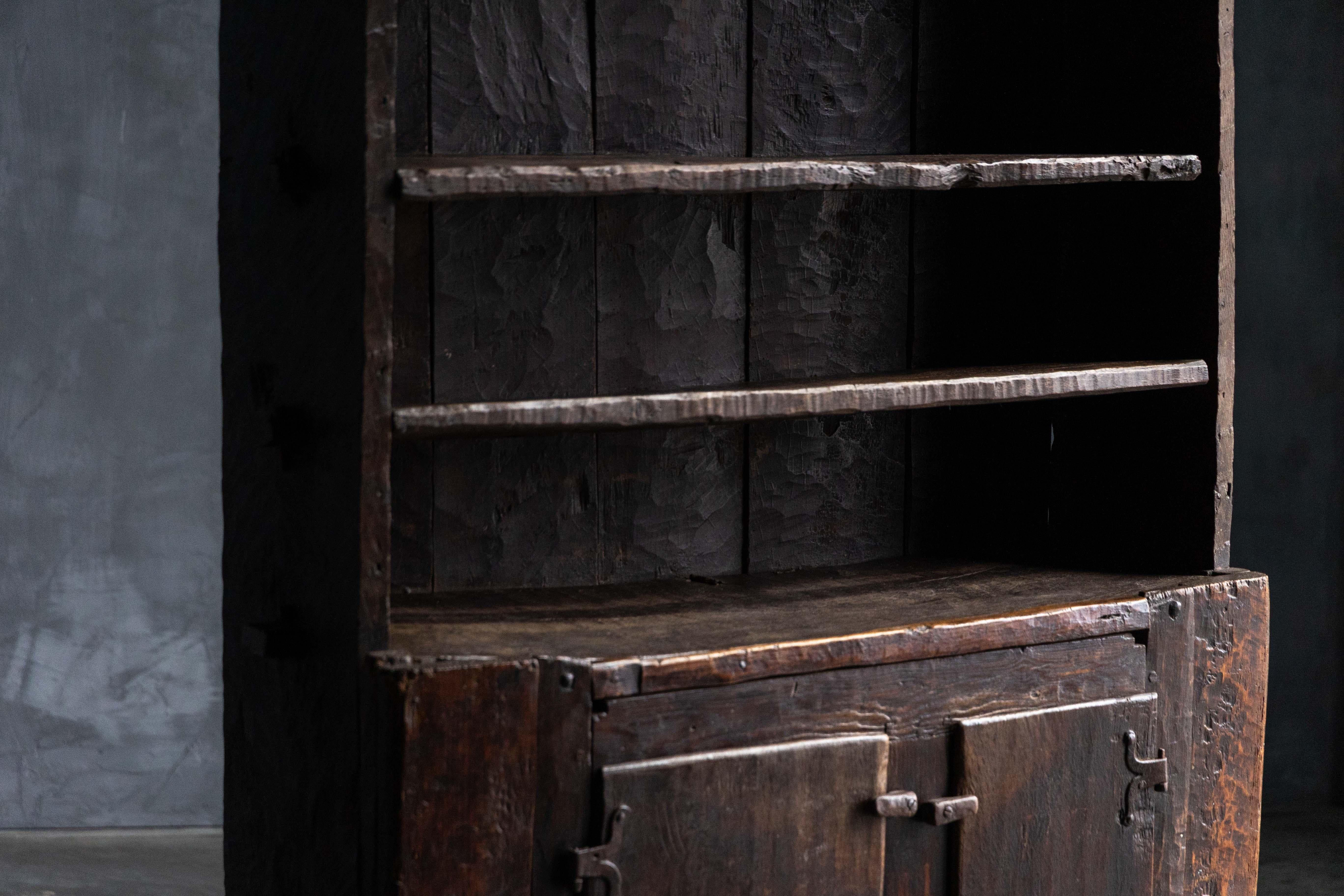 Questo squisito mobile risale al XVIII secolo e proviene dalla Francia; mostra un'eccezionale abilità artigianale e una patina che si ottiene solo con l'età. Il suo design rustico e sorprendente è caratterizzato da ripiani aperti e due ante