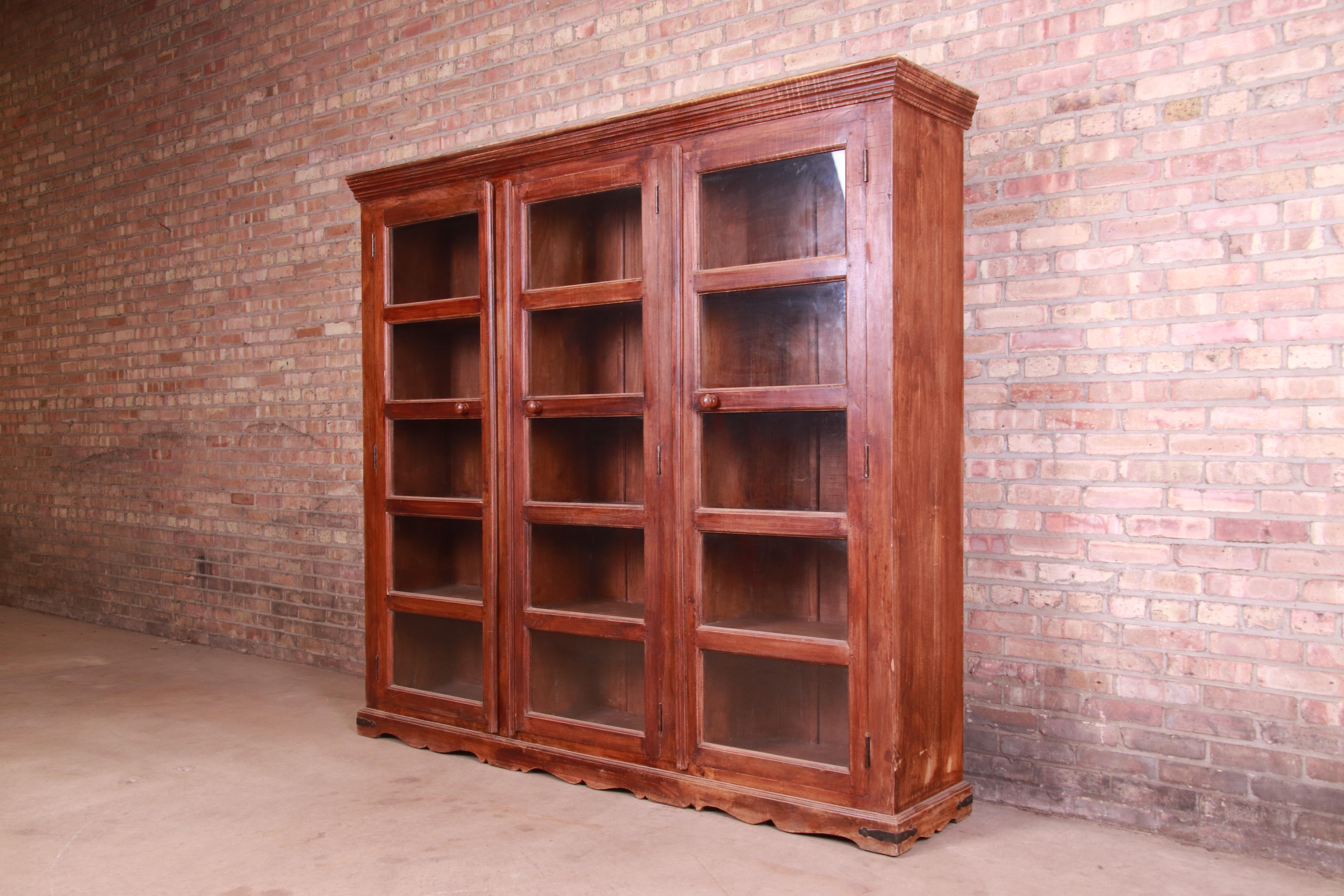 A gorgeous antique rustic style triple bookcase

Circa 1900

Carved walnut, with glass front doors.

Measures: 81.5