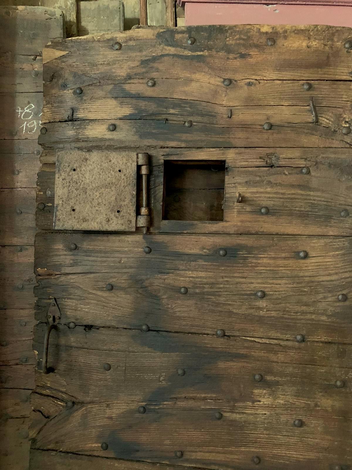 Ancient chestnut door, rustic with spiked planks, complete with original opening window (probably overlooking a stable or cellar), beautiful construction tools and patina from past centuries, hand-built in the 19th century for a rustic house in