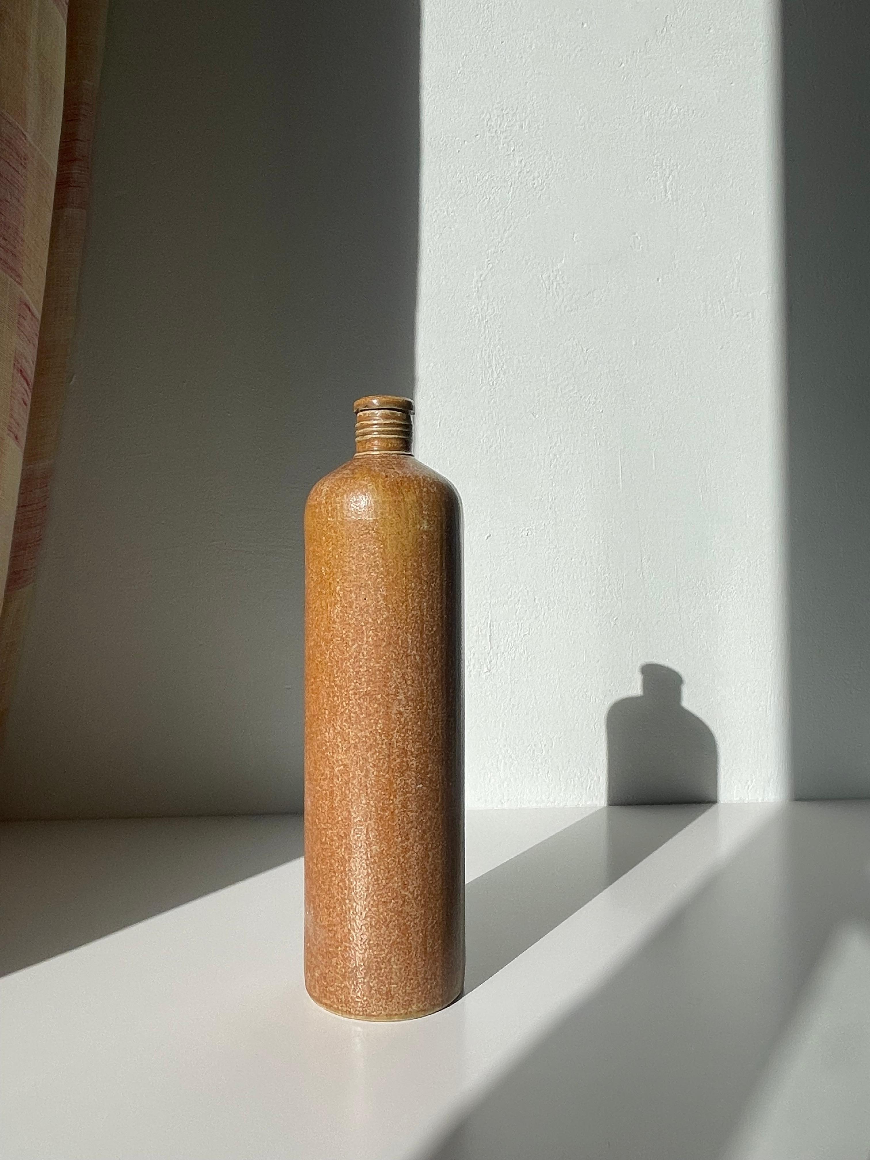 Antike Wasserflasche aus Steinzeug, hergestellt von der deutschen Firma MKM in den 1930er Jahren. Hohe Zylinderform mit schmalem Hals - perfektes Dekorationsobjekt oder Vase für ein paar Zweige. Warme karamellfarbene Salzglasur. Schöner