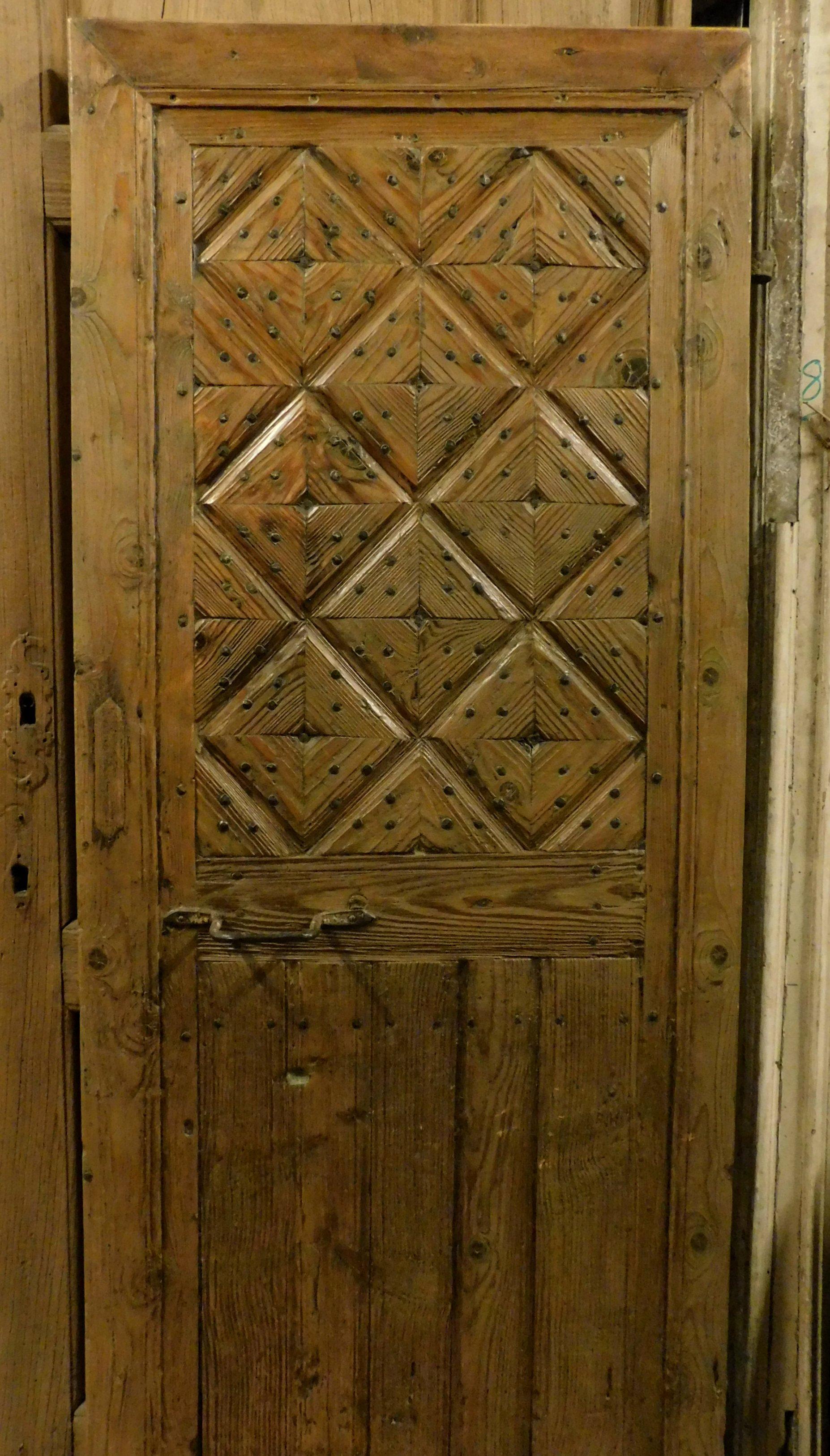 Antique rustic door in blond larch, yellowish color with natural wood effect, sculpted with geometric effects, give prominence and rusticity to a door that could be introduced into a mountain chalet with its own elegance and character. Italian