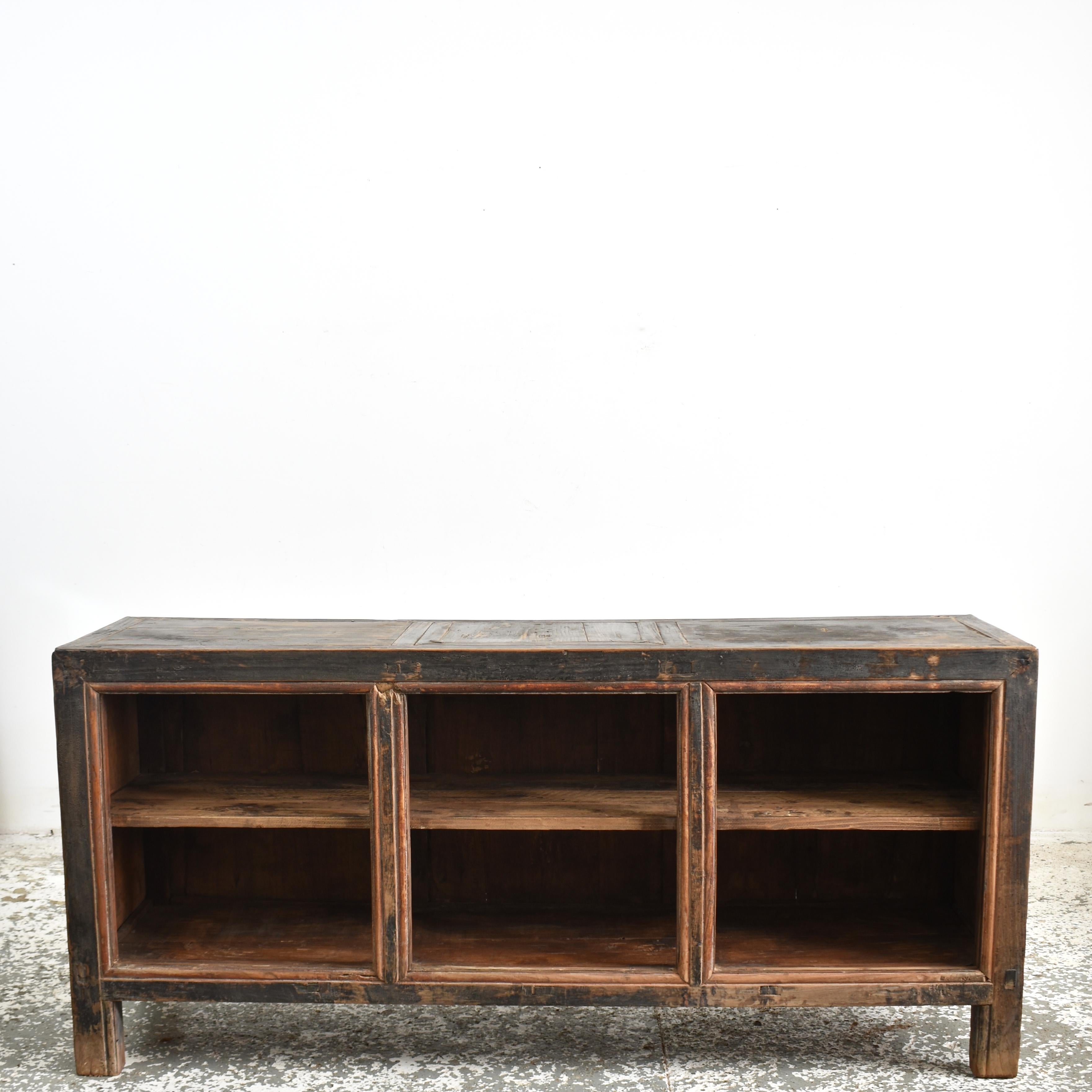 Antique Rustic Elm Haberdashery Kitchen Island Storage Sideboard – E

A lovely rustic open fronted storage shelving sideboard. The cabinet is constructed from elm wood with a pine panelled back. There is a central shelf which continues behind the 2