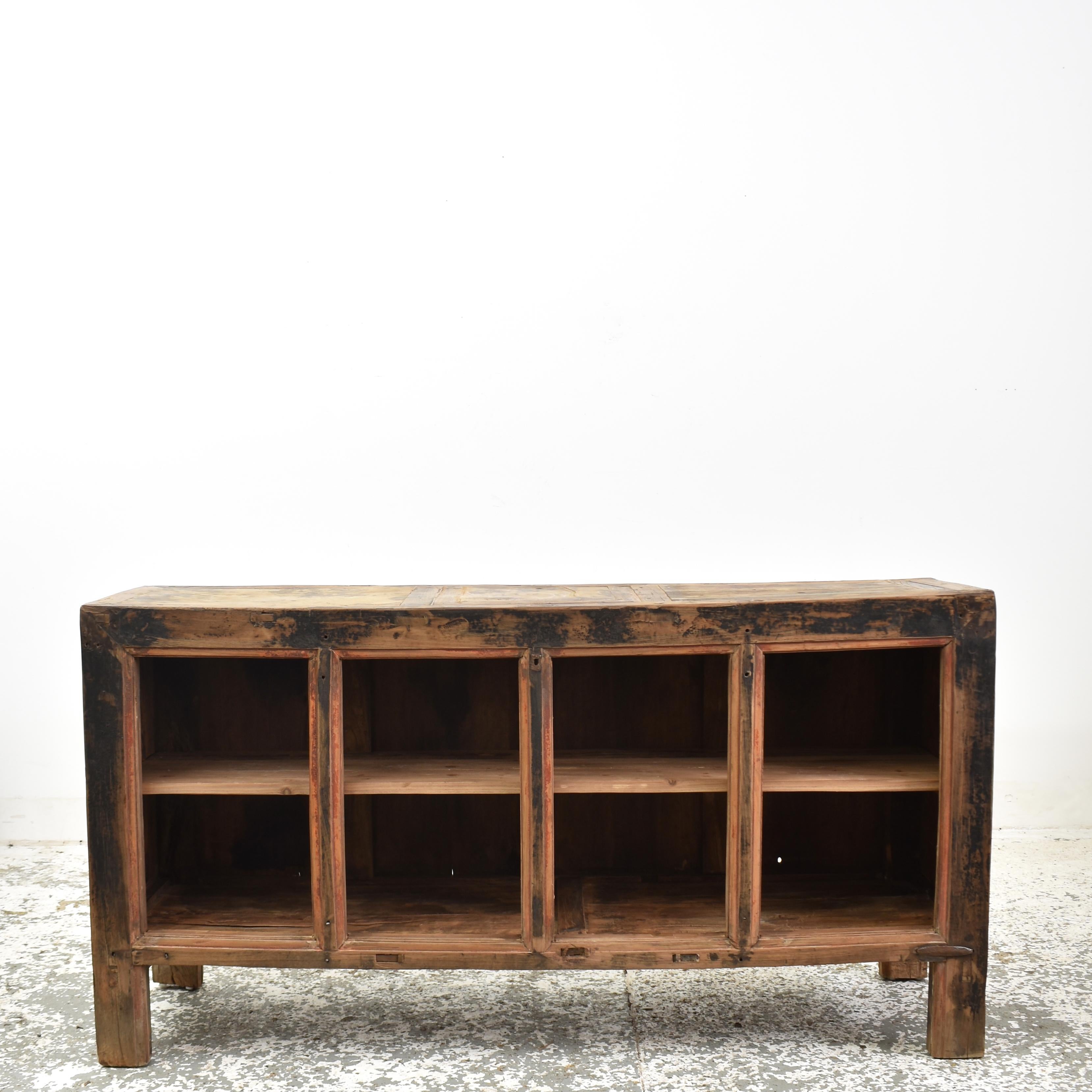 Antique Rustic Elm Haberdashery Kitchen Island Storage Sideboard – C

A lovely rustic open fronted storage shelving sideboard. The cabinet is constructed from elm wood with a pine panelled back. There is a central shelf which continues behind the 3