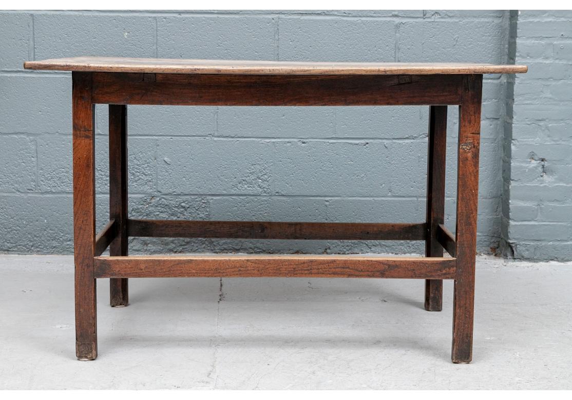 An authentic and timeworn Antique English  tavern table with three boards, box stretcher and resting on straight legs.
Dimensions: 28 1/2