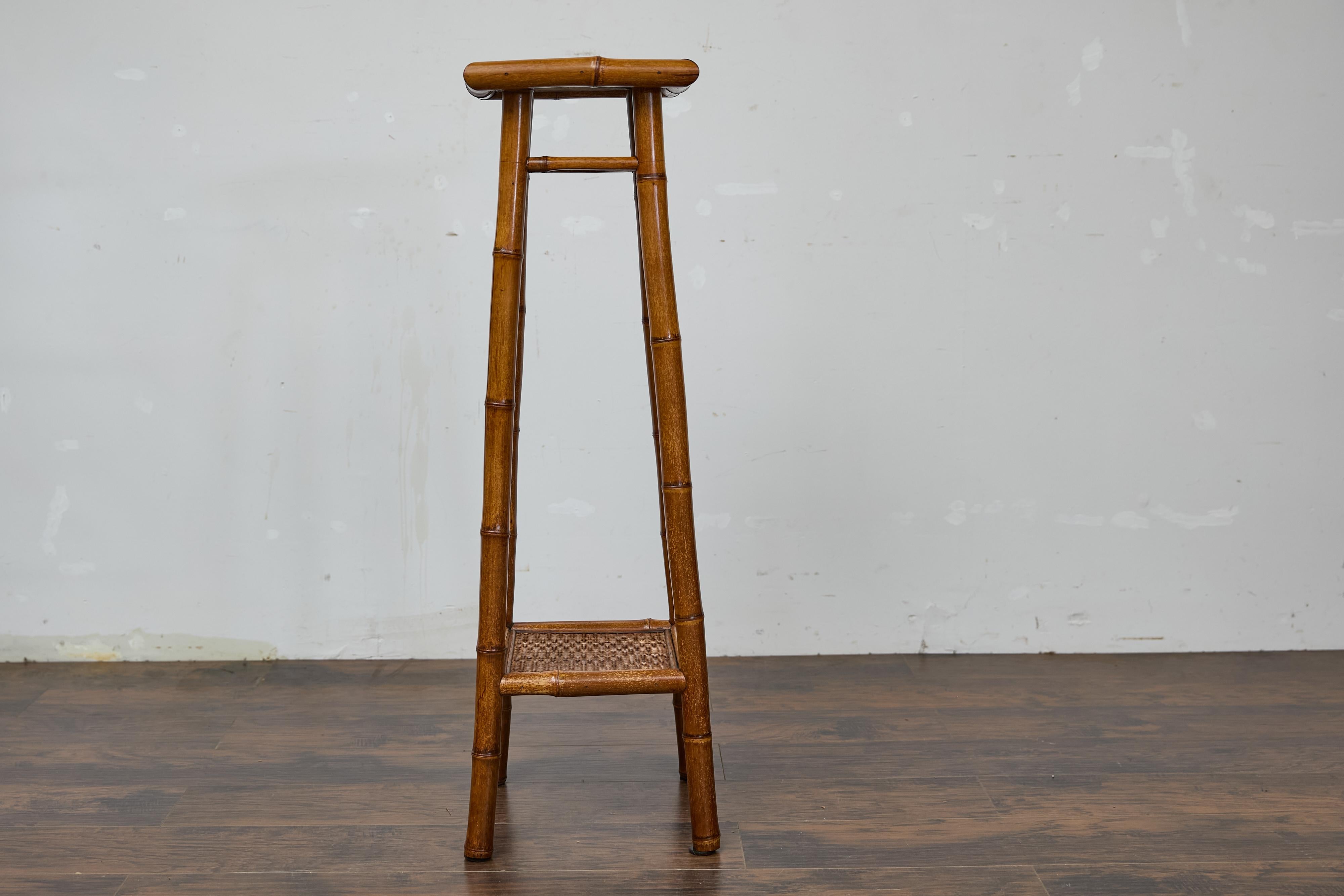 Questo supporto in finto bambù in noce inglese, del 1920 circa, combina eleganza e funzionalità. Realizzato con un'imponente struttura in finto bambù, è alto ben 45 pollici. La finitura in noce naturale ne esalta il fascino senza tempo, mentre i