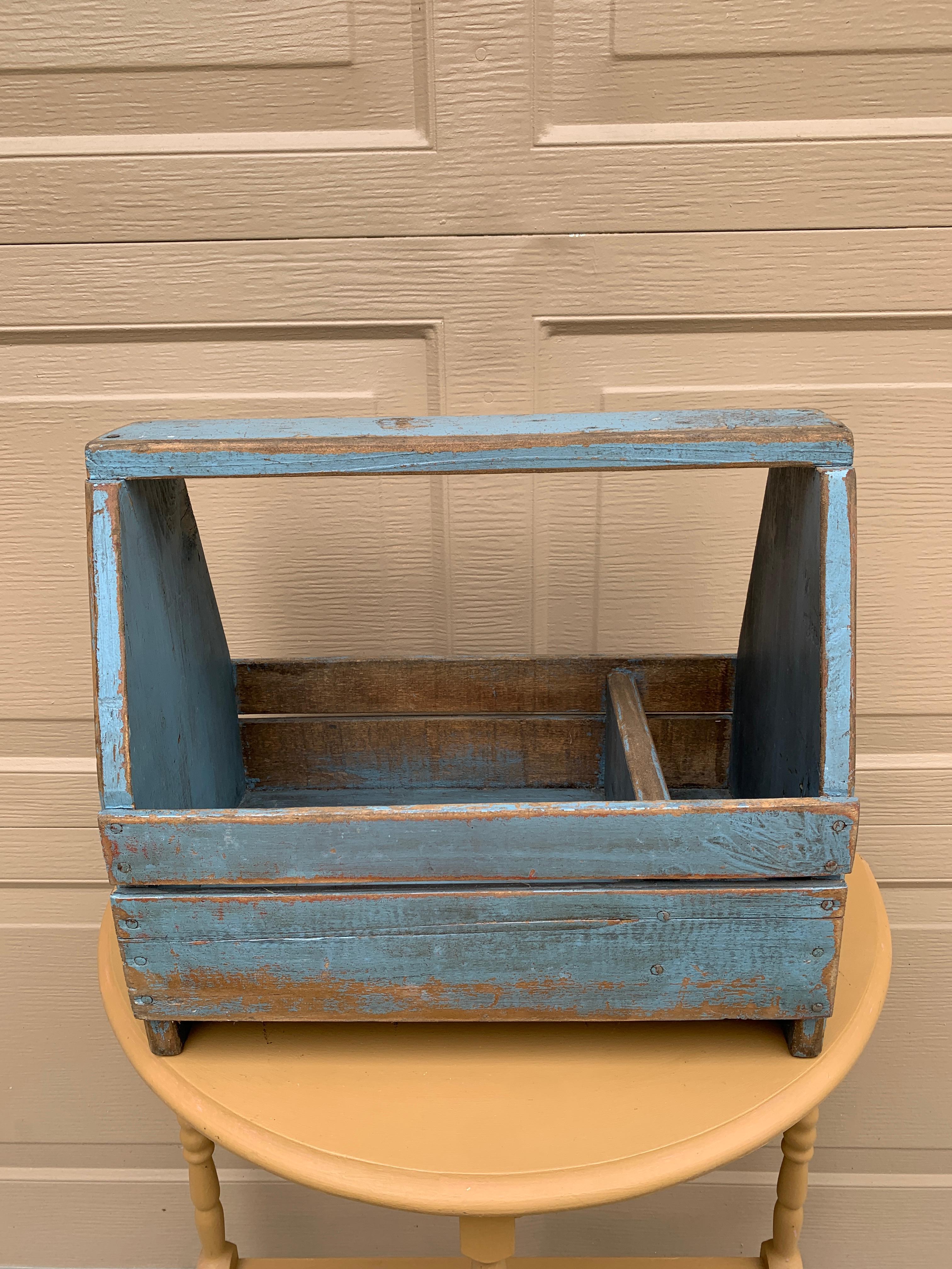 A charming country farmhouse wooden tool box trug painted in a beautiful blue. This piece would be ideal as a craft organizer, silverware holder, or garden tool box.

Iowa, USA, Late 19th Century

Measures: 16.25