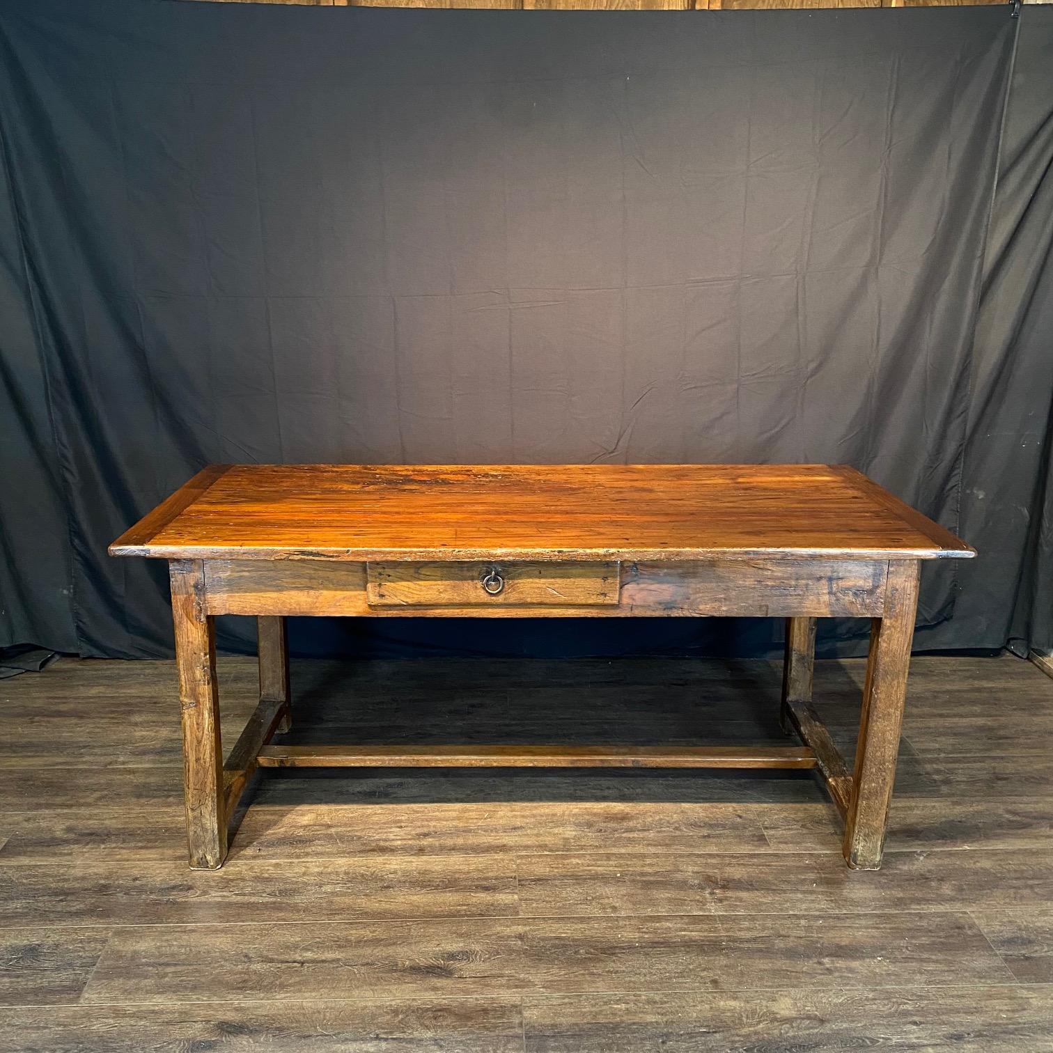 Classic country French primitive oak dining table made in France in the early 19th century. The table was made in solid oak and has beautiful grain patterns and one storage drawer. It has a lovely aged patina, and could also serve as a wonderful