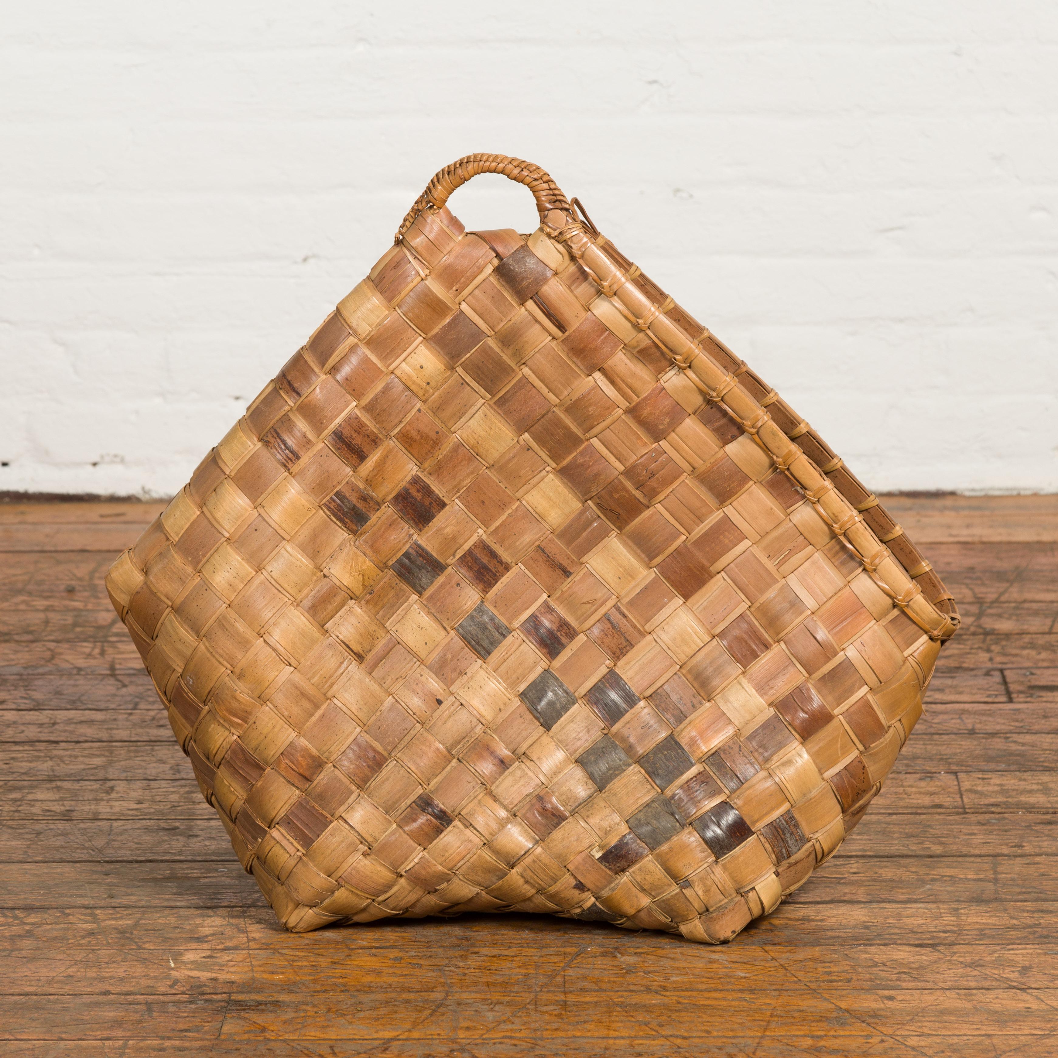 A hand woven karagumoy Filipino basket from the 19th century, with checkered two-toned structure, side opening and rustic character. Created in the Philippines during the 19th century, this decorative basket could be used as a newspaper or magazine