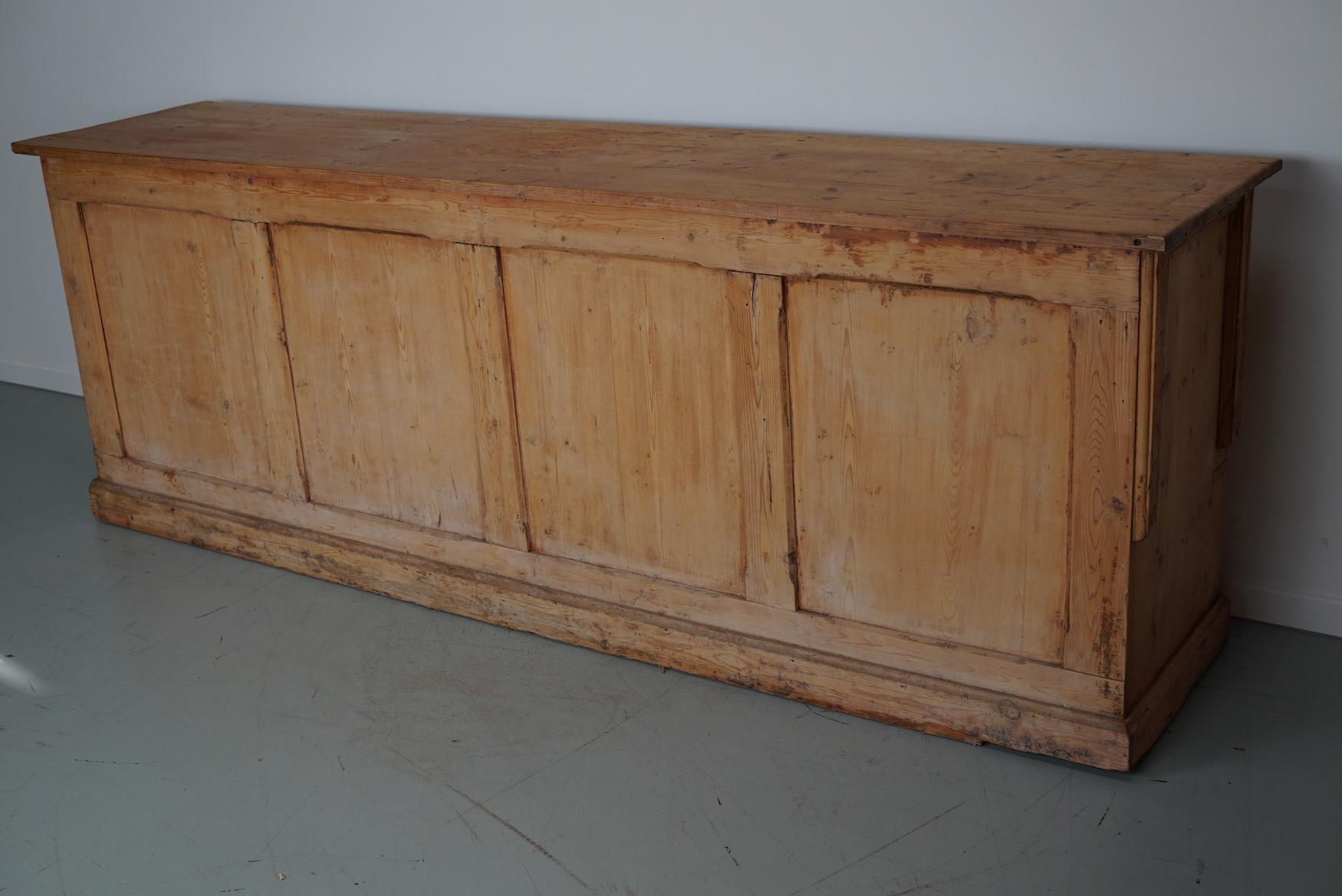 This apothecary bank of drawers was designed and made circa 1900 in Germany. It is made from pine with metal handles and name plates for the contents. The cabinet has retained a rich patina with some natural distressing and rustic looks.