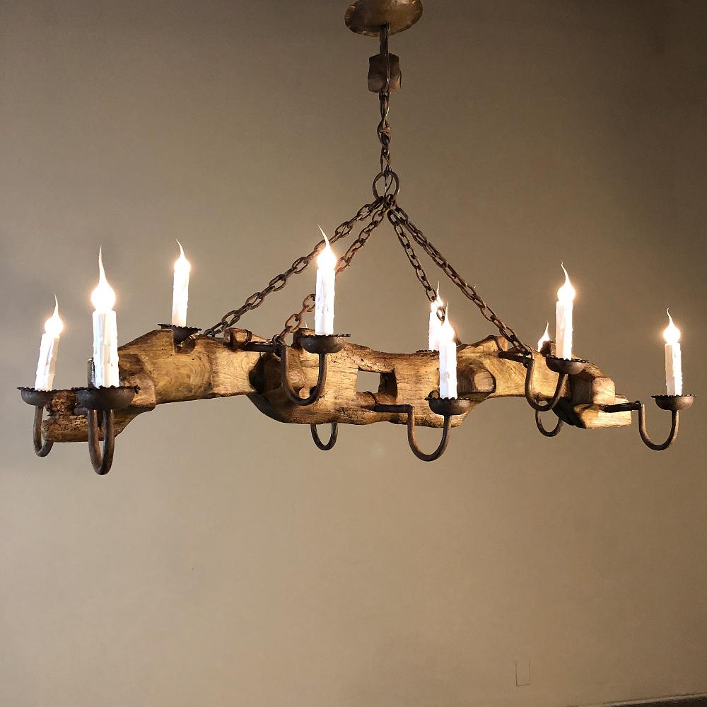 Antique rustic ox yoke with wrought iron chandelier is a charming example of repurposing items of antiquity! Here an old ox yoke has been fitted with ten hand forged wrought iron arms and bobeches which have been electrified, included in the price!