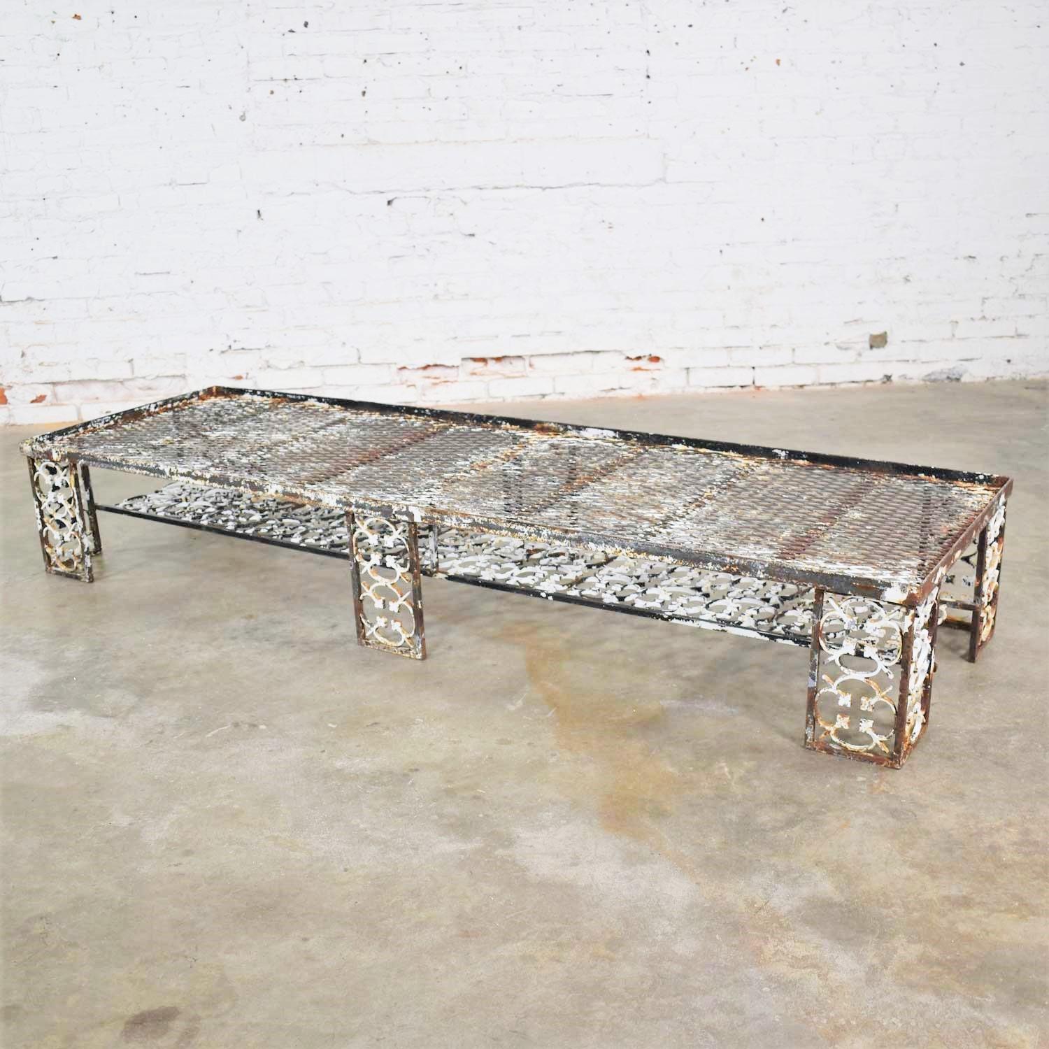 Handsome antique ornate, rustic and patinated cast iron outdoor patio, or garden large coffee table, bench, or daybed. It is in fabulous antique condition with lots of beautiful age patina including chipping paint and a little rust. Please see