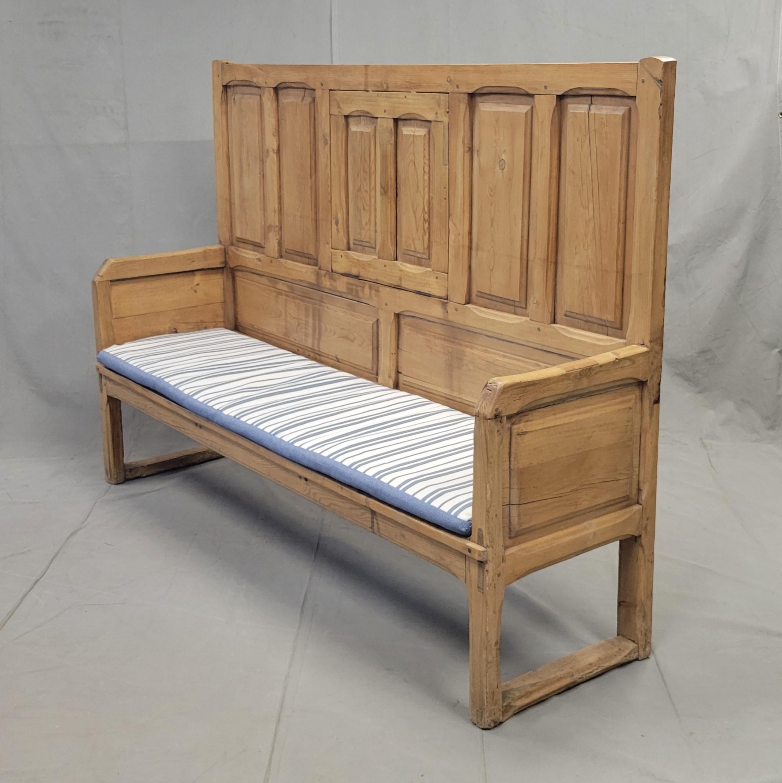 This charming antique pine long settle bench would add a rustic touch to an entryway, dining area or hallway. Stunning in a kitchen or dining room as banquette seating! The tall paneled backrest and armrests are beautifully crafted and give this