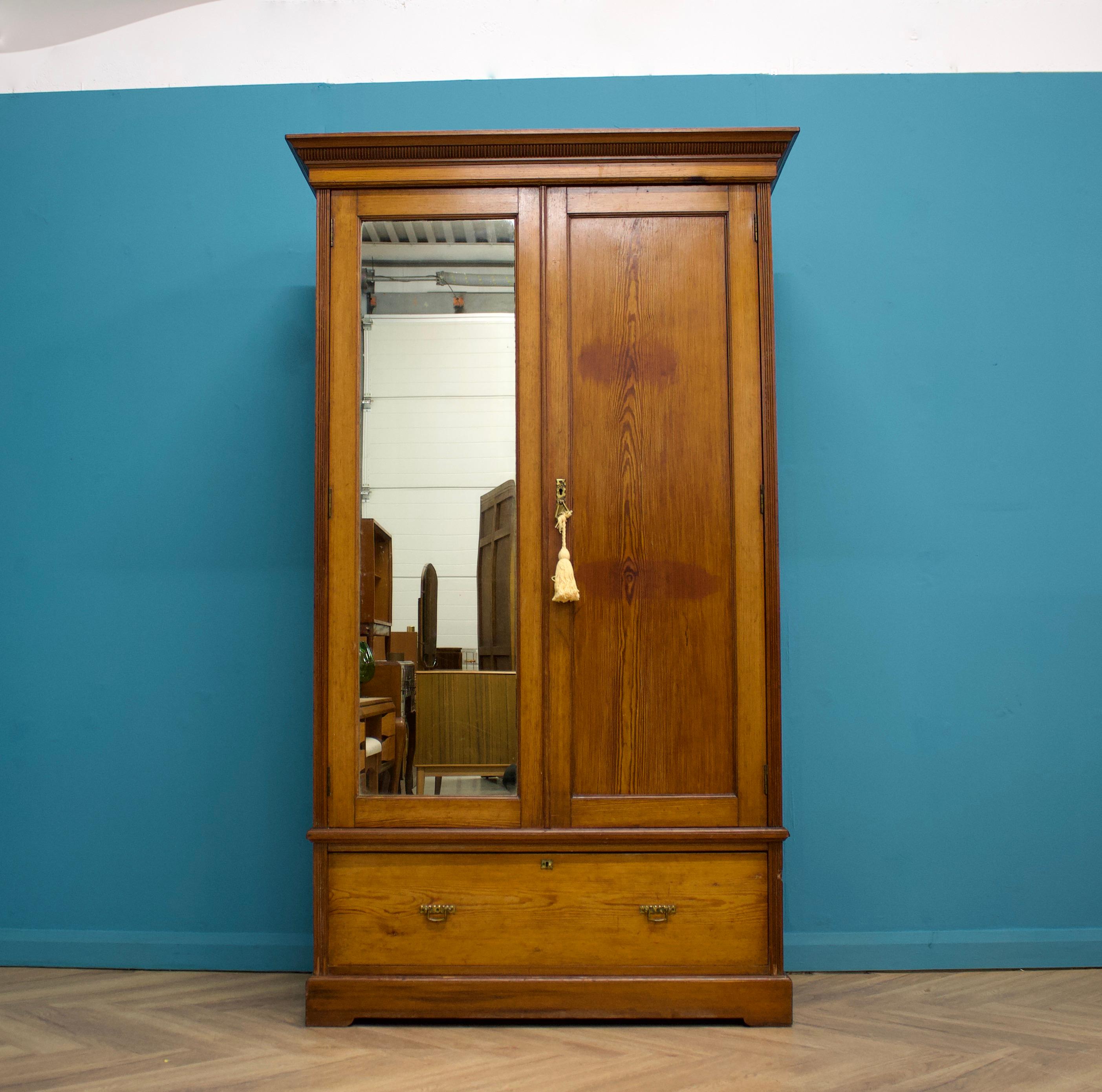 A quality Edwardian pine wardrobe or hall cupboard

Constructed from solid pine
The exterior is in good rustic condition - there is a mirrored door, internally there is a rail and coat hooks
There is a further drawer to the bottom