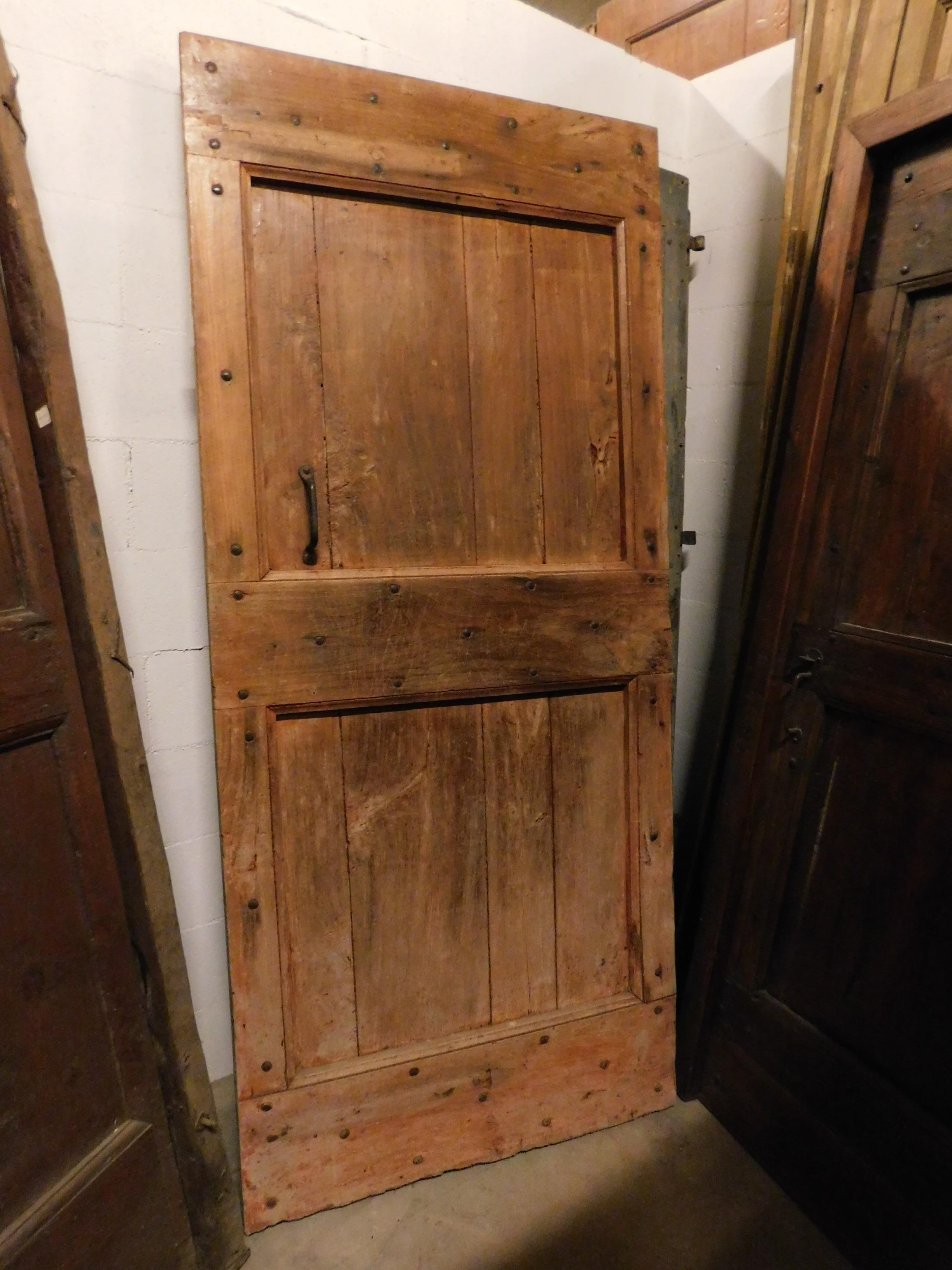 Antike rustikale Tür aus Pappelholz, die Farbe des hellen Pappelholzes tendiert zu Orange, schönes patiniertes Holz aus dem 19. Jahrhundert, handgefertigt für ein Bauernhaus in Norditalien.
Es wurde als Kellertür geboren, mit Original-Öffnung und