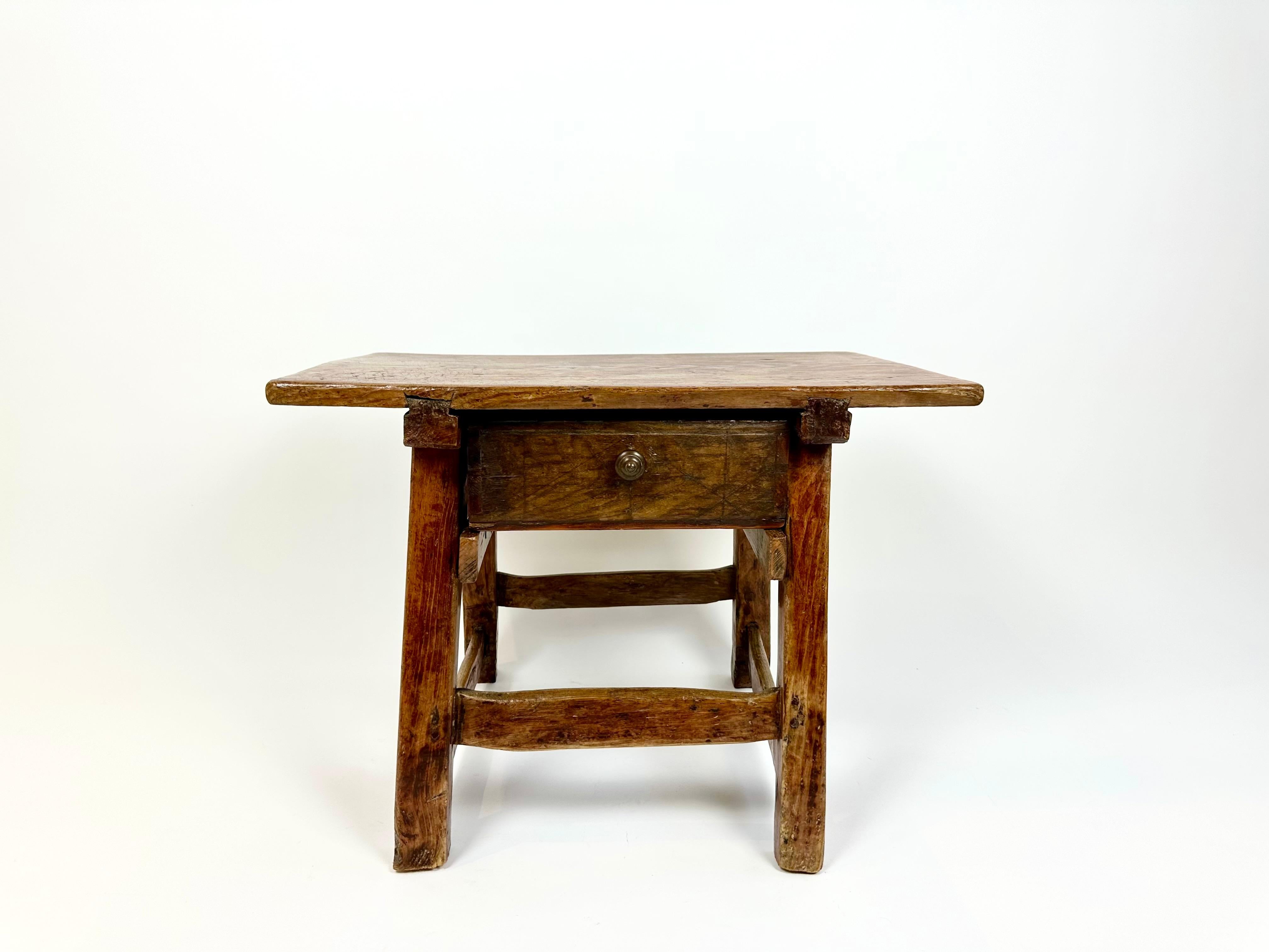 Mesa auxiliar rústica antigua de los Alpes franceses, finales del siglo XIX.

Fabricado artesanalmente con madera de pino gruesa, uniones con clavijas y un cajón de cola de milano de otra madera con un inusual dibujo tallado. Maravillosa